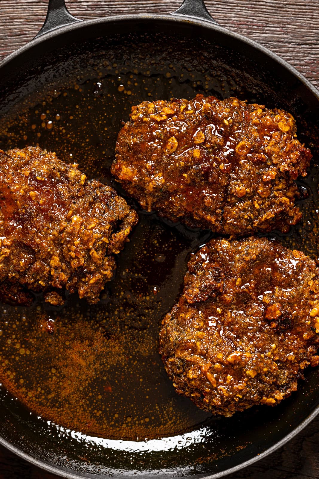 Hot honey crispy chicken breasts in a skillet.