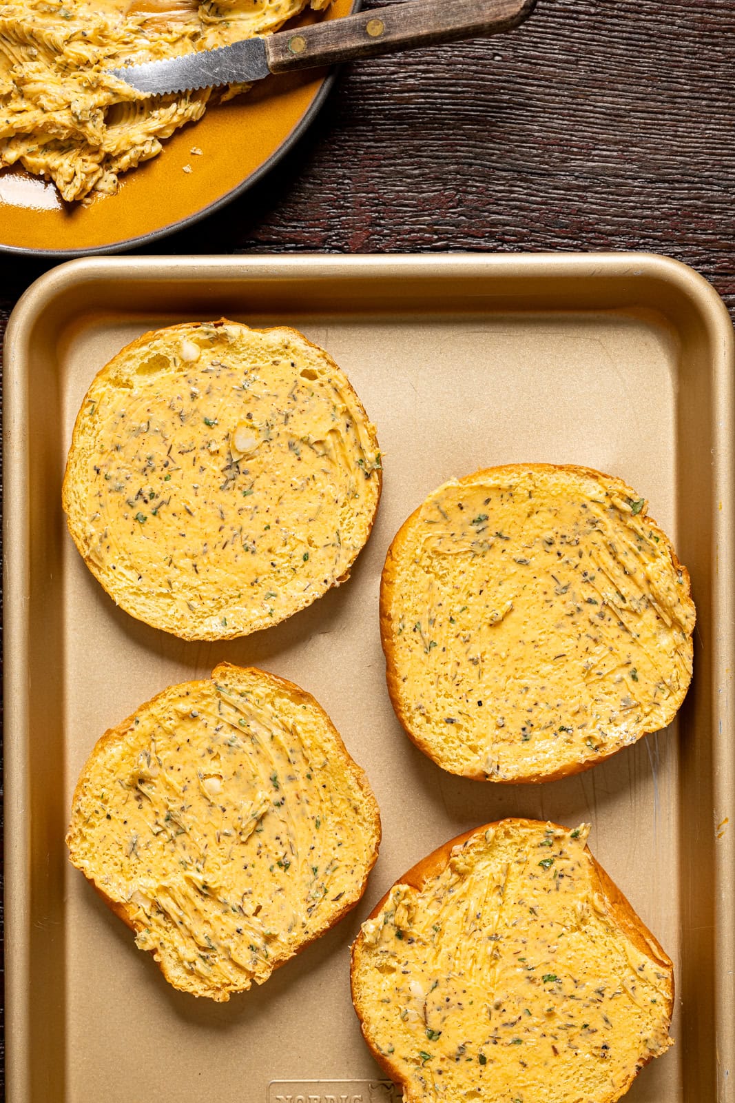 Buns on a baking sheet with herb butter.