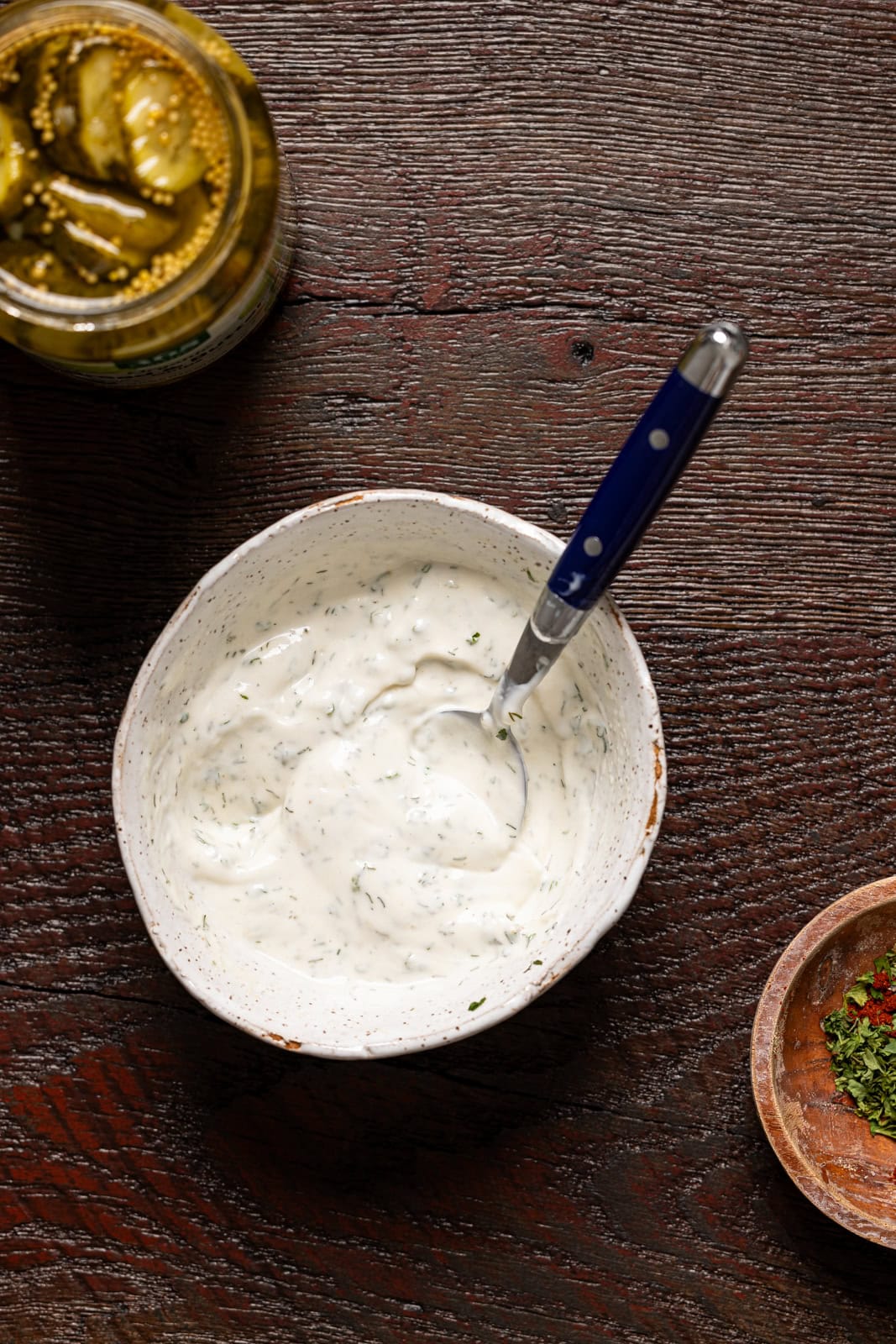 Ranch sauce in a white bowl with a spoon.