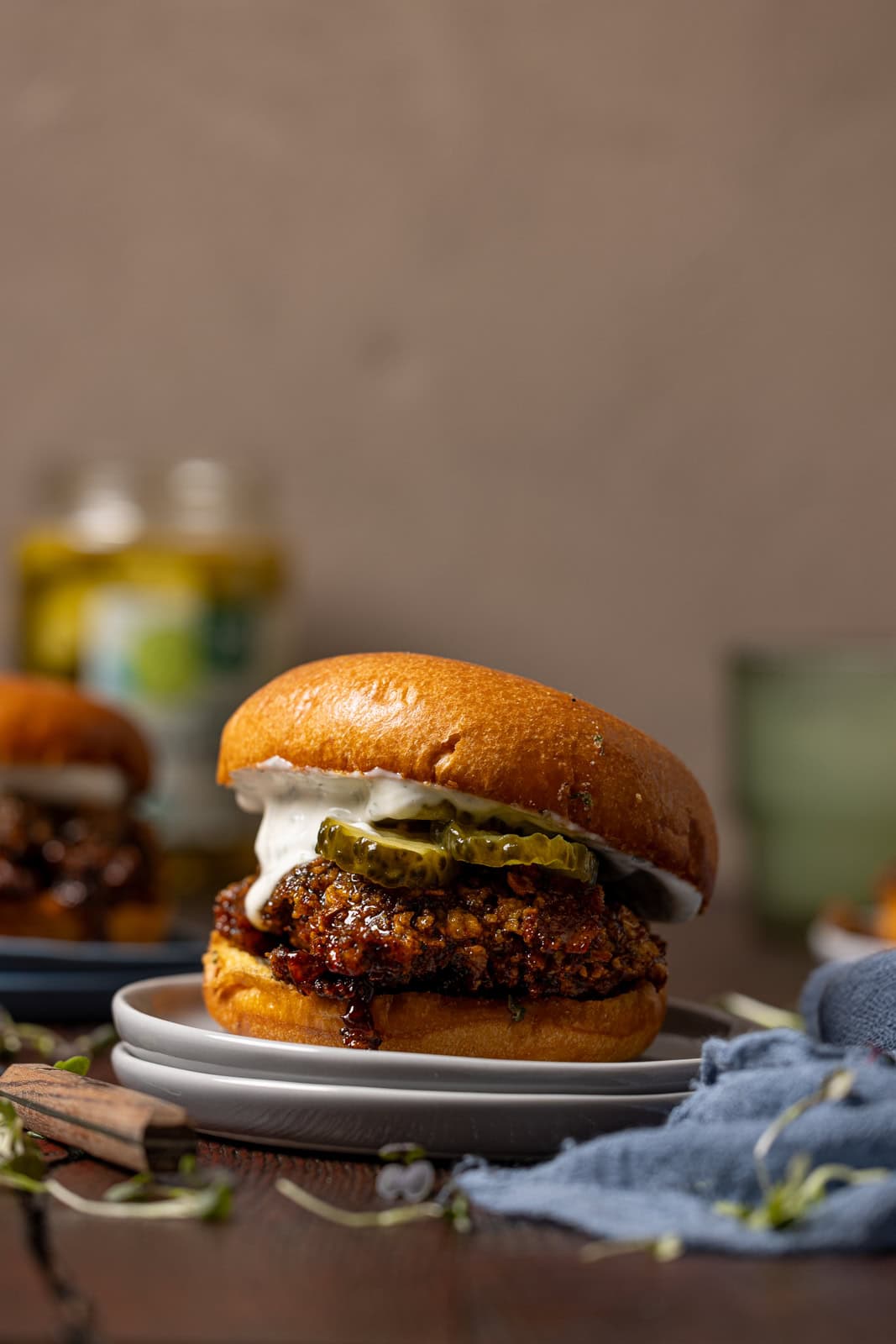 Hot honey crispy chicken sandwich with drinks in the background and a sandwich. 