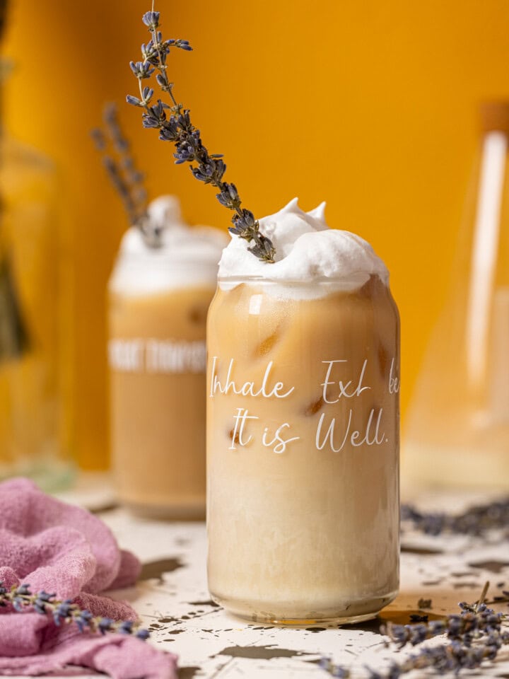 Two glasses of iced lattes with lavender flowers.