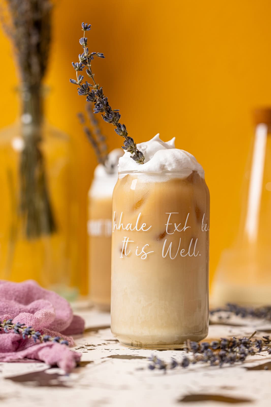 Two glasses of iced lavender lattes.