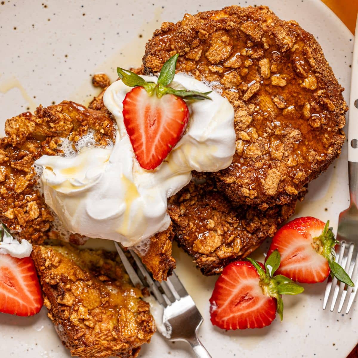 Up close shot of french toast on a plate with two forks.