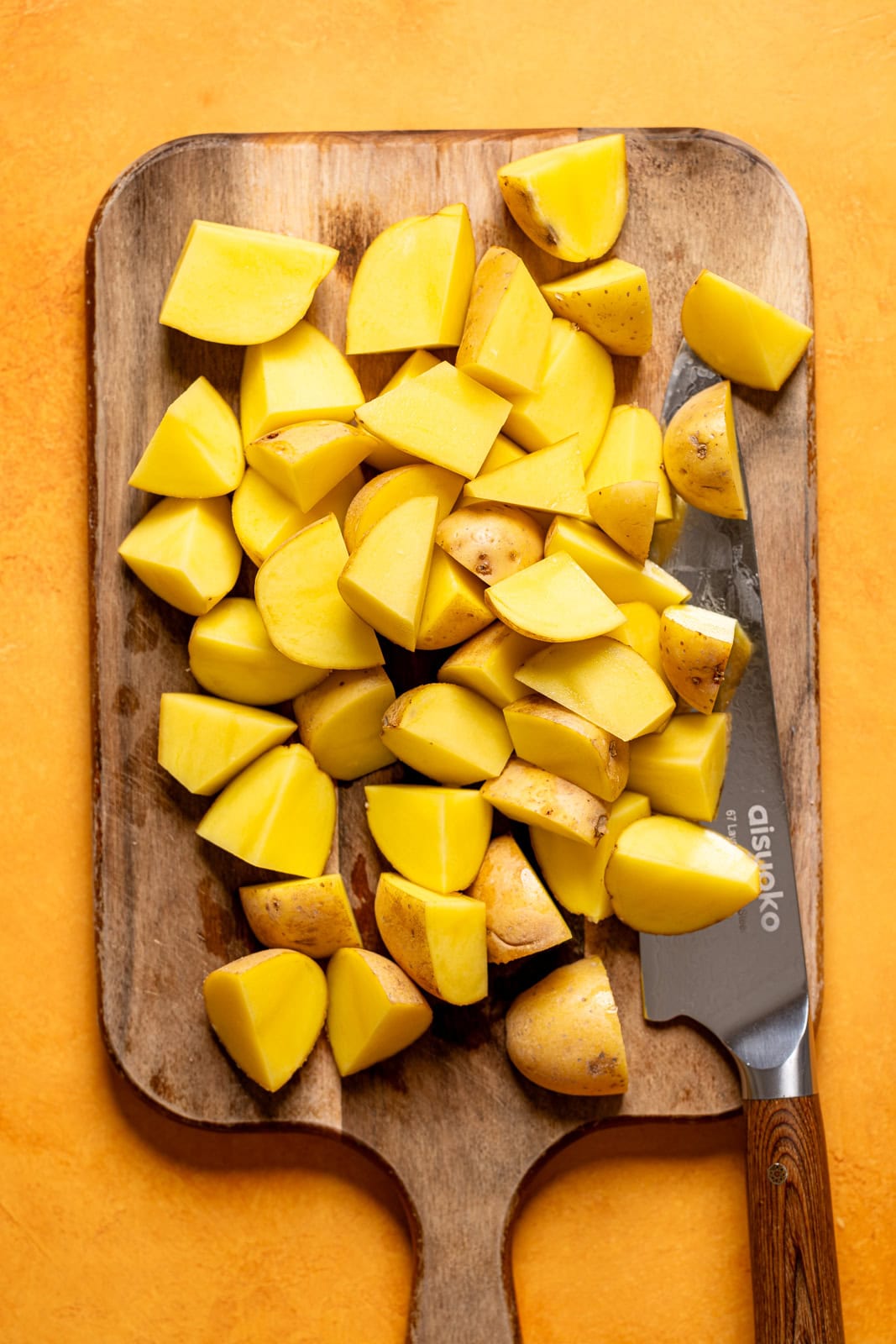 Chopped potatoes on a cutting board with a knife.