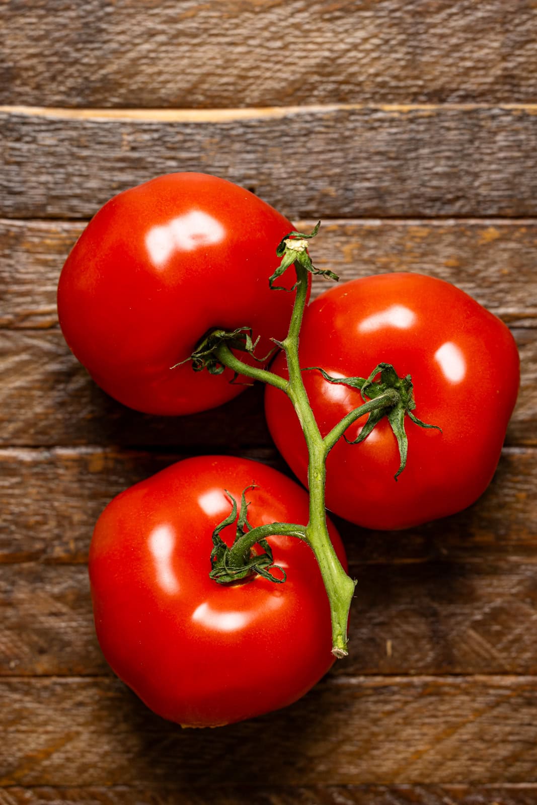 Tomatoes on a brown wood table.