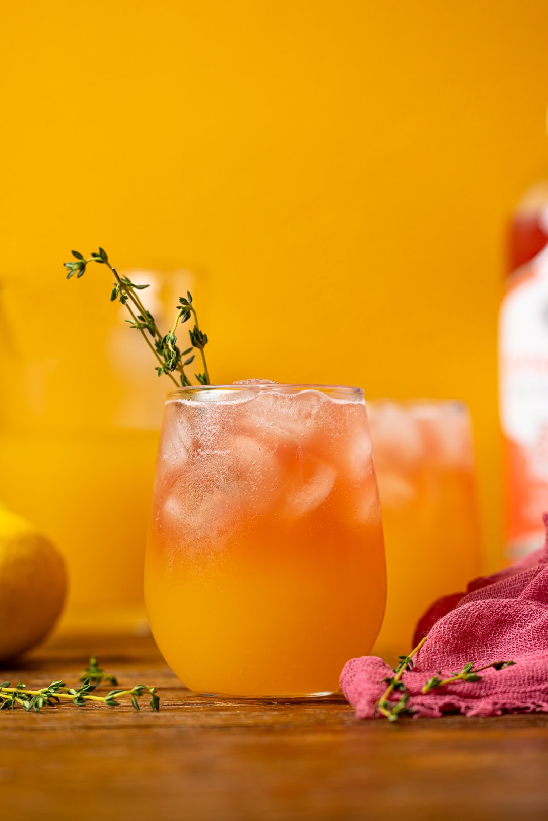Two glasses of lemonade on a brown wood table.