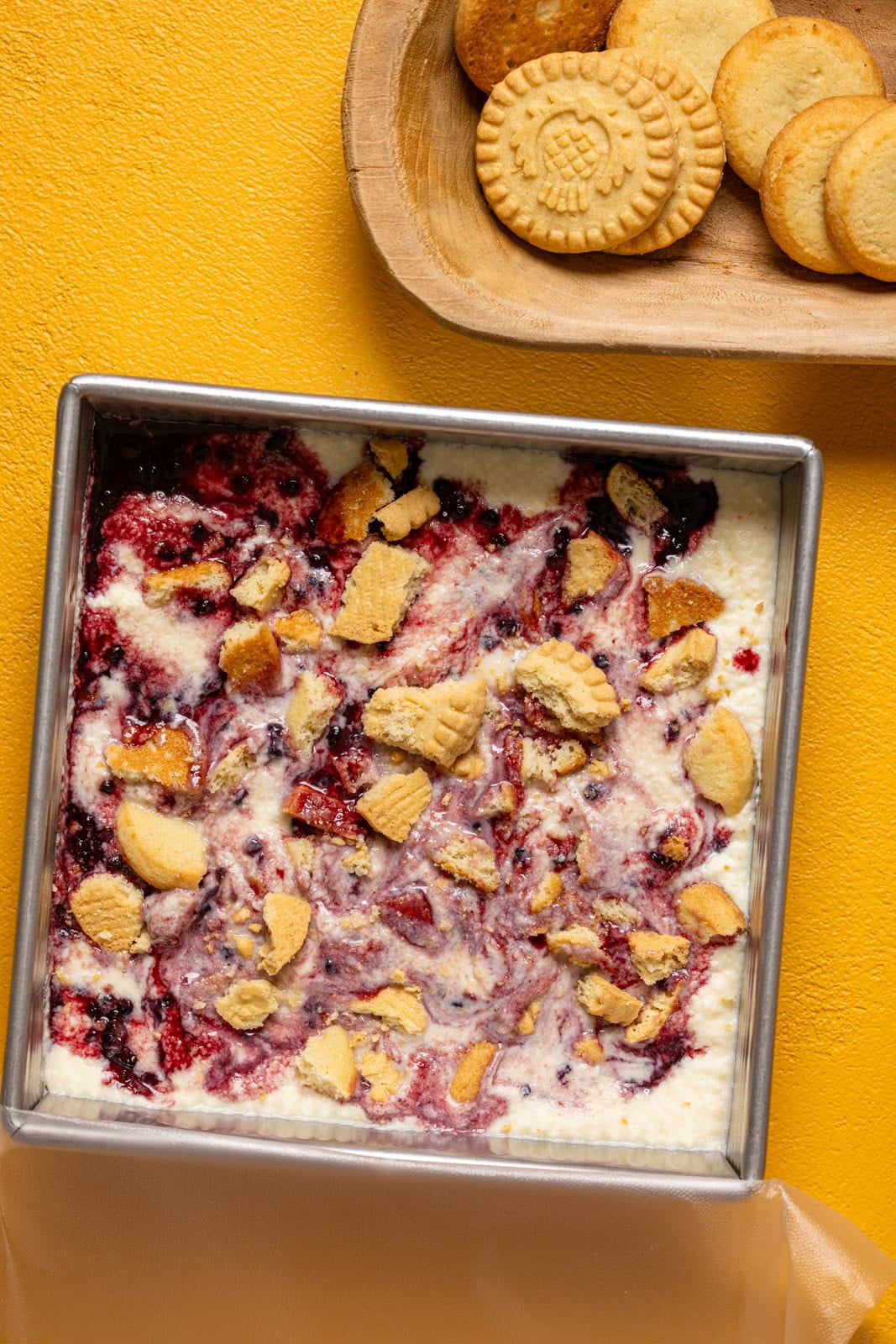 Frozen ice cream in a square metal container with cookies.