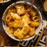 Bowl of mac and cheese on a wood table with forks.