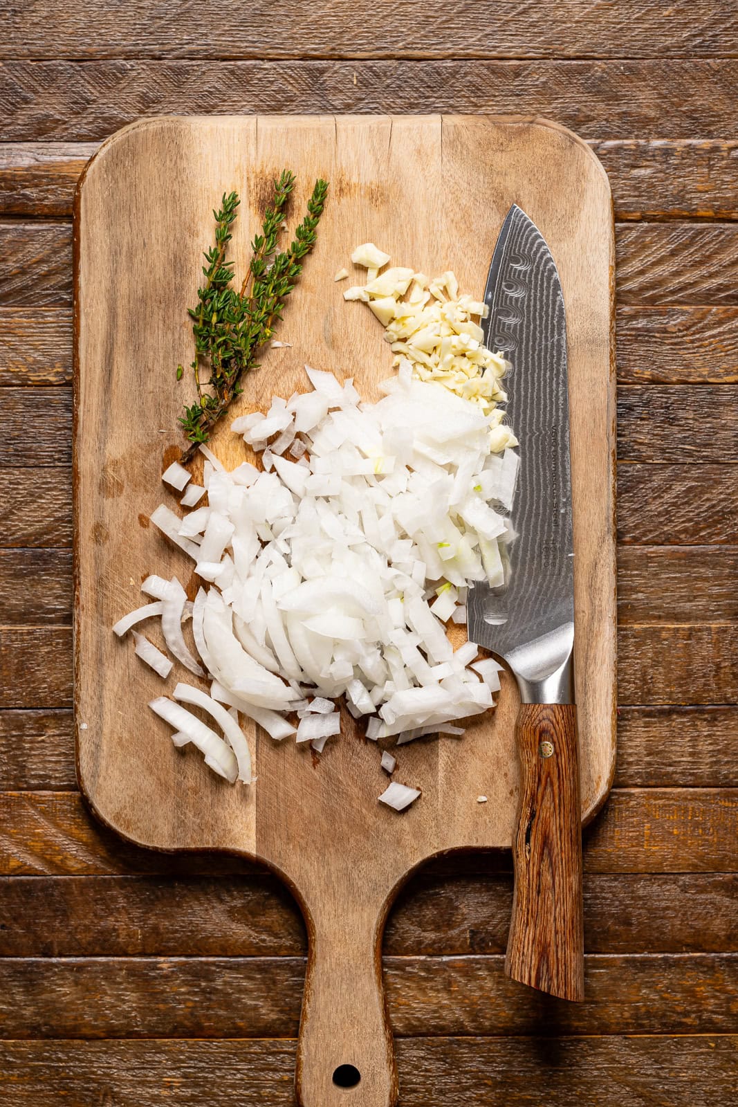 Chopped veggies on a cutting board with a knife.
