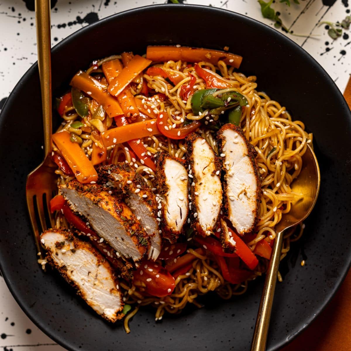 Up close shot of spicy chicken ramen in a black plate.
