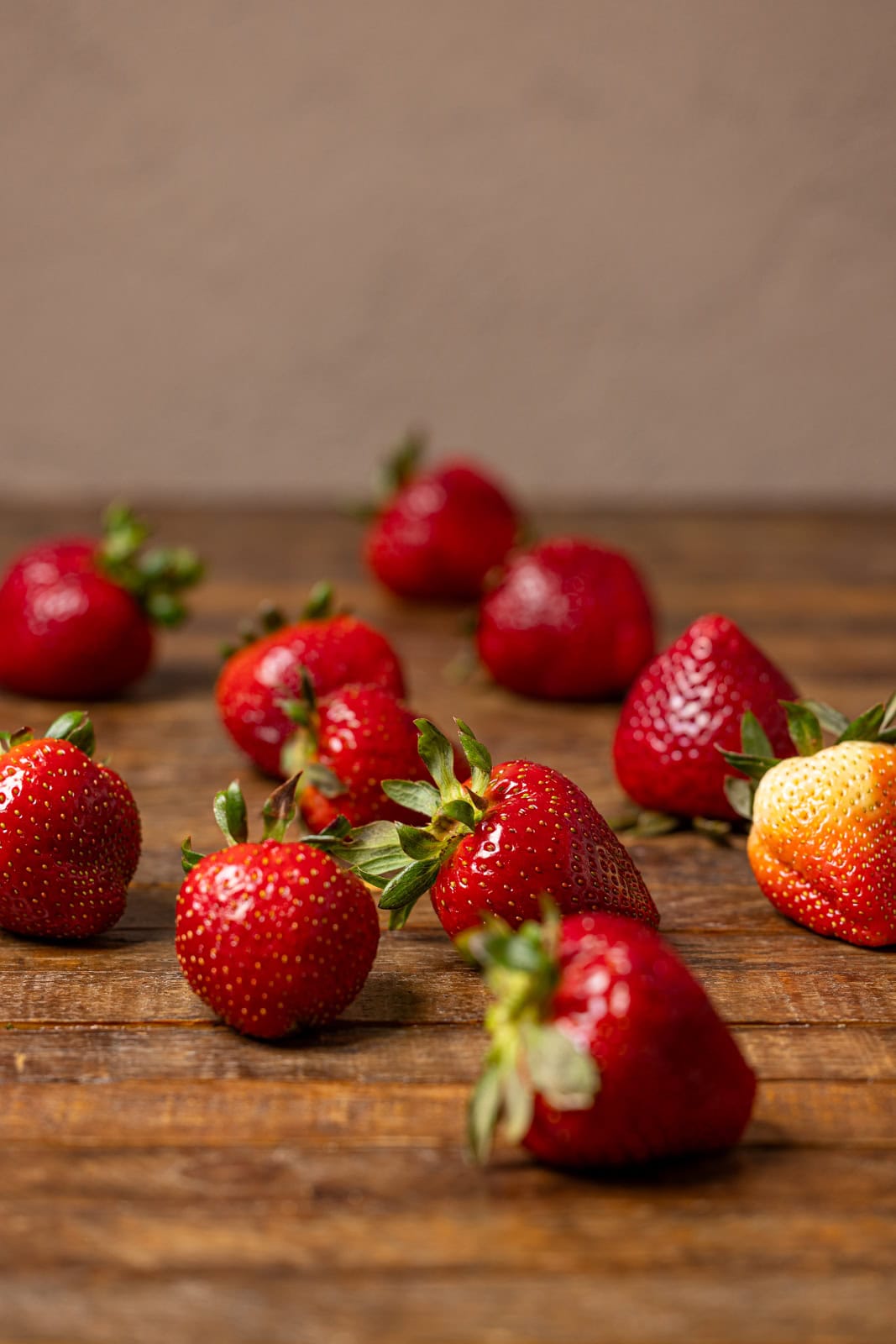 Fresh strawberries on a brown wood table.