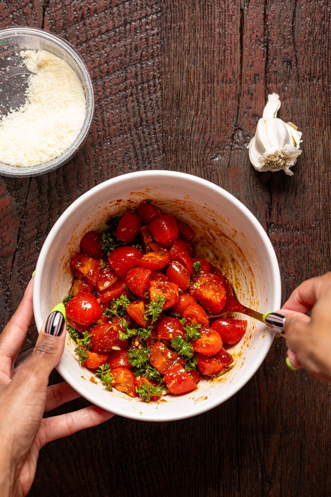 Bruschetta topping being stirred together in a bowl.