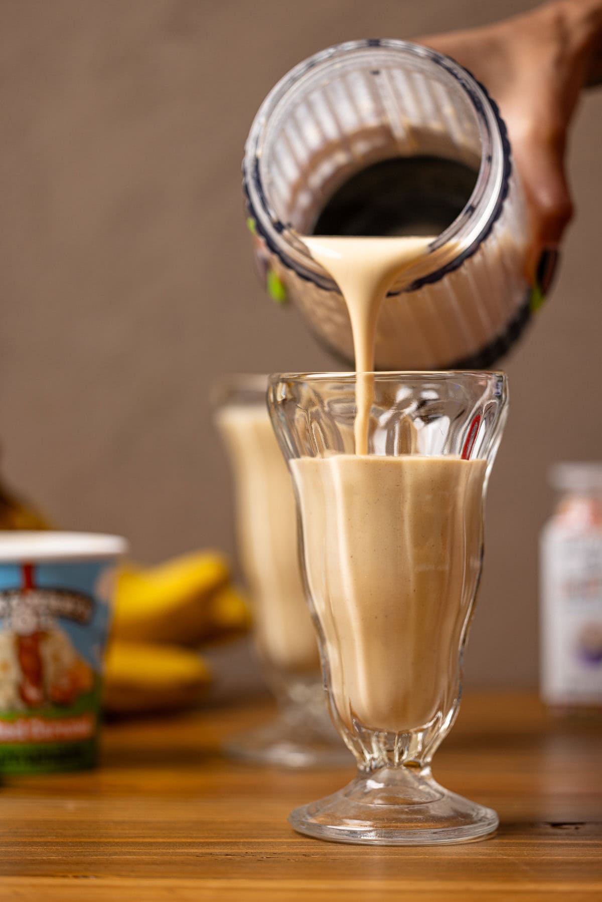 Milkshakes being poured from blender into glasses. 