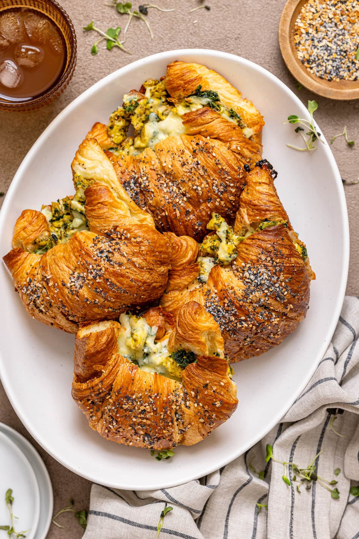 Stuffed breakfast croissants on a platter with a drink.