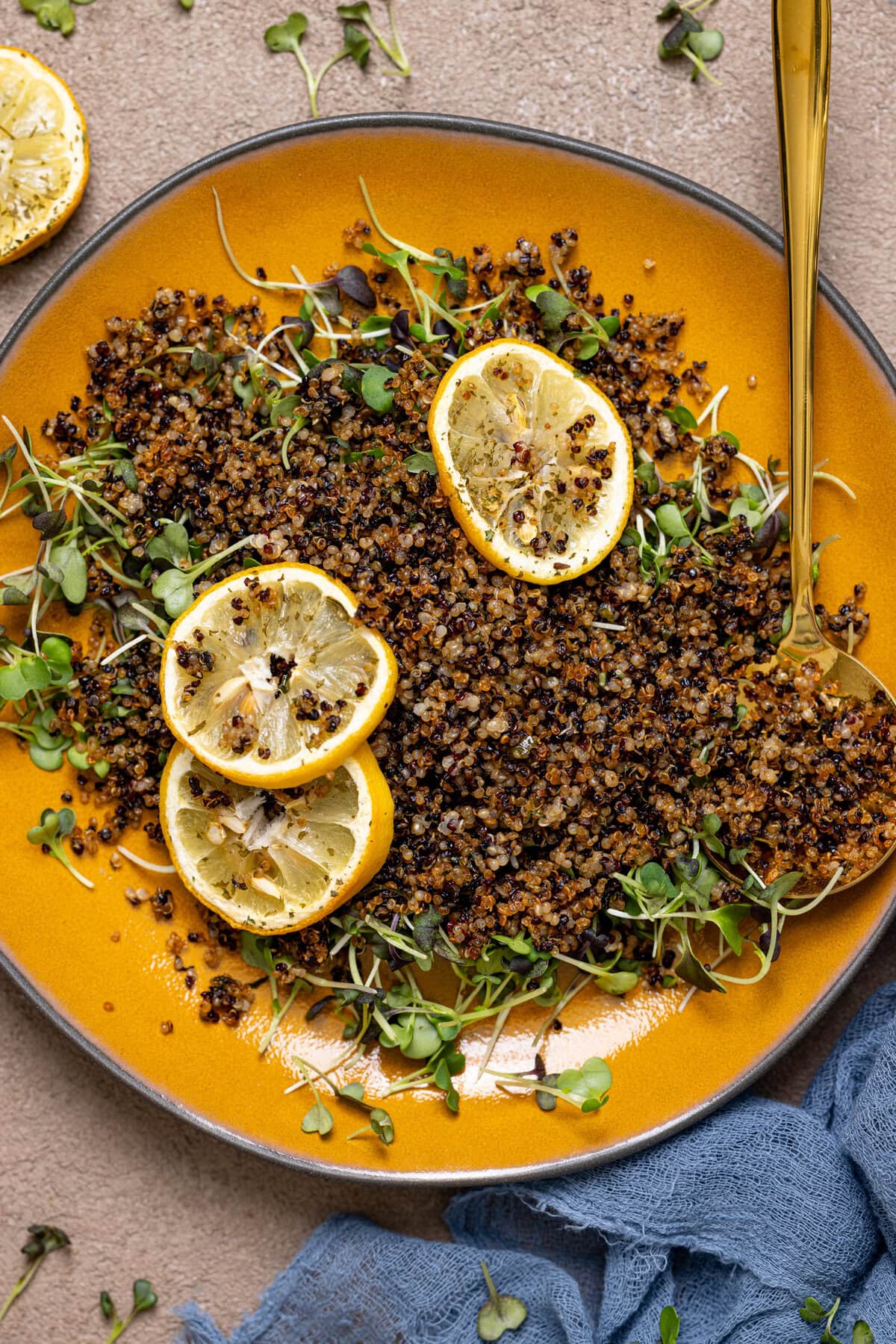 Up close shot of crispy quinoa on a yellow plate with a spoon.