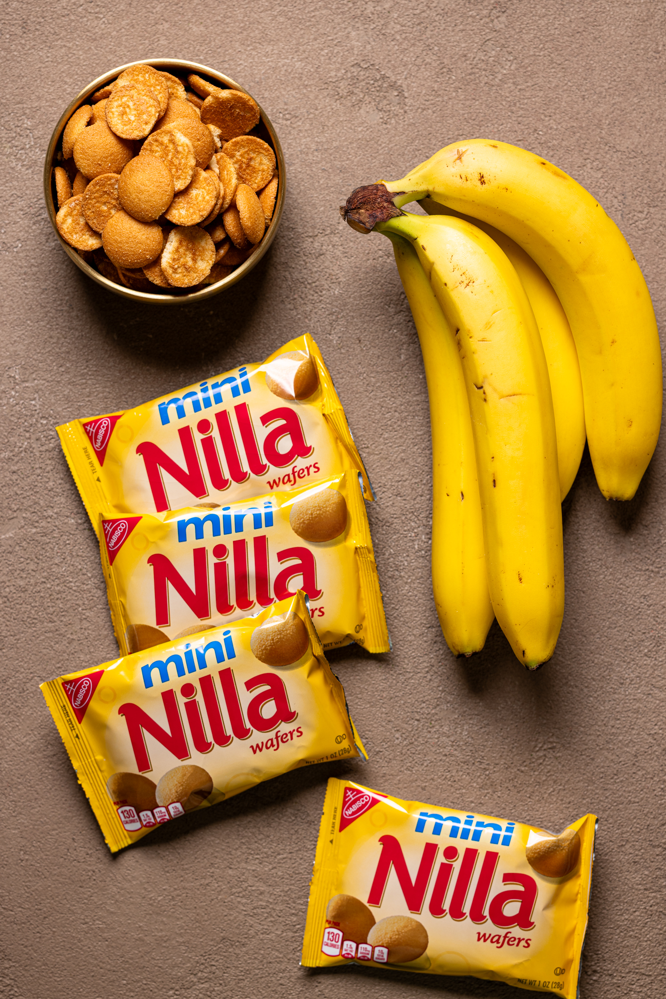 Image of ripe bananas and Nilla wafer cookies on a brown-greyish table.