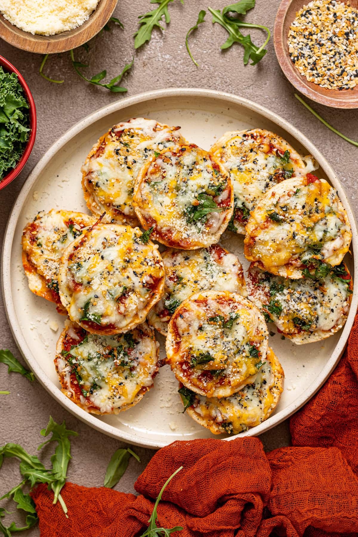 Pizza bites on a serving tray with garnish ingredients. 