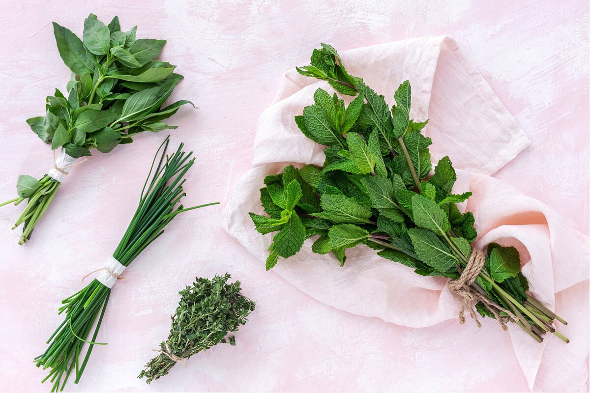 Image of herbs on a pinkish cloth.