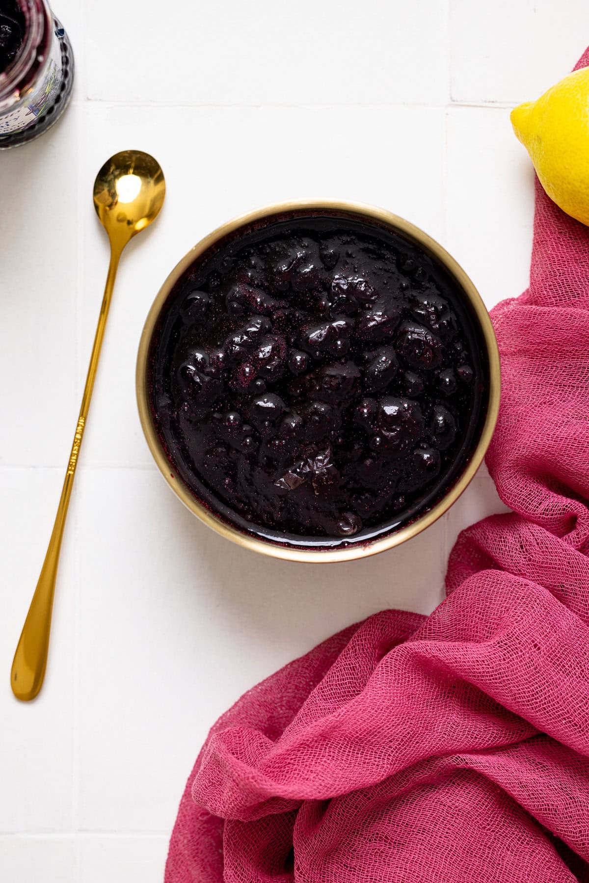 Blueberry compote in a bowl with a spoon.
