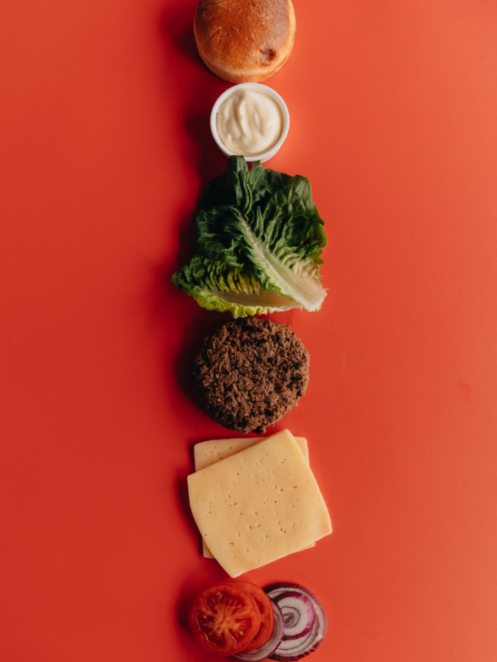 burger ingredients on red background