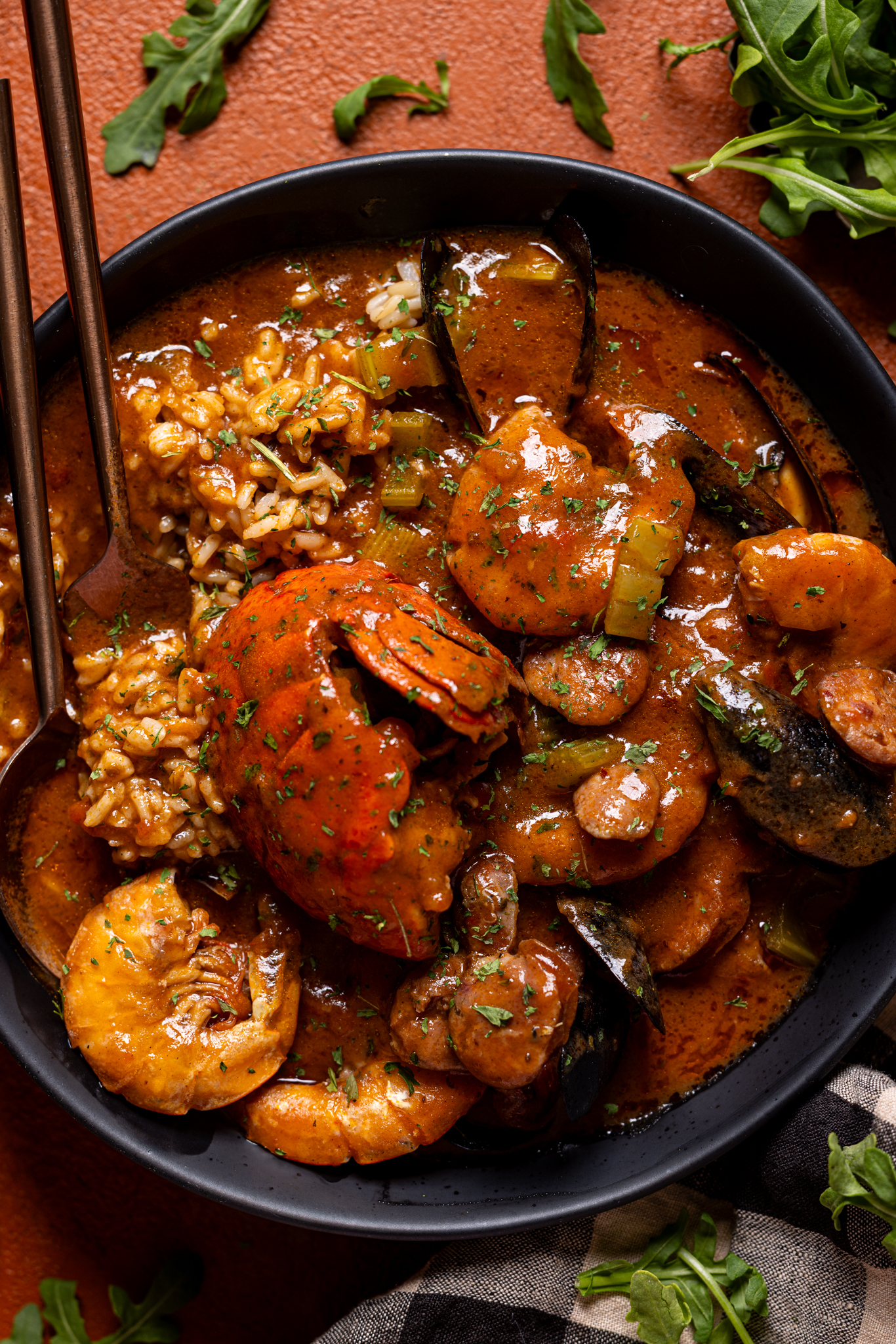 Up close shot of seafood gumbo with two spoons.