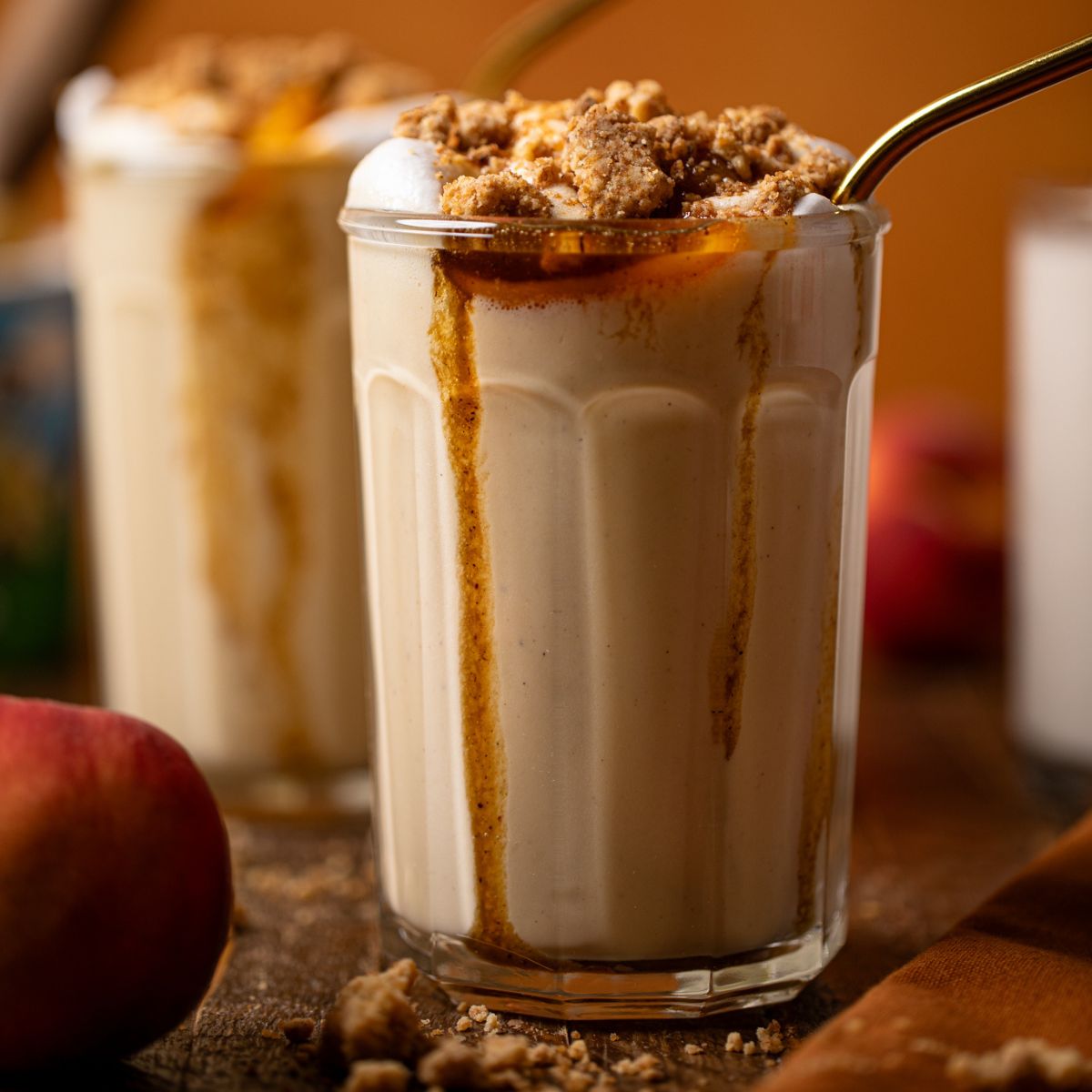 Up close shot of two glasses of peach cobbler milkshake.