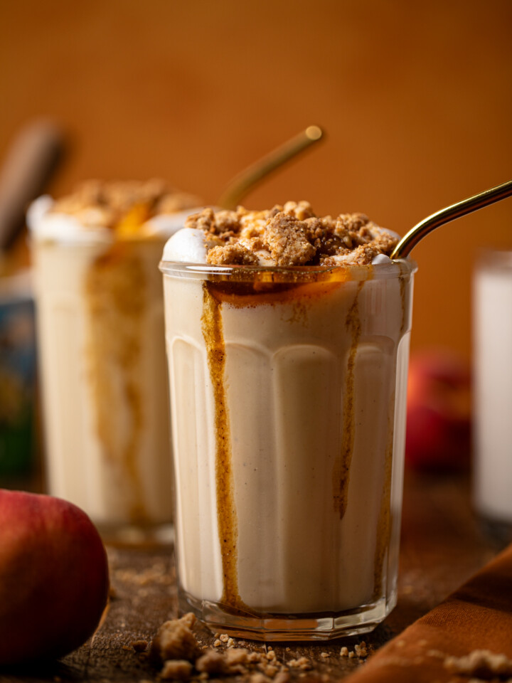 Up close shot of two glasses of peach cobbler milkshake.