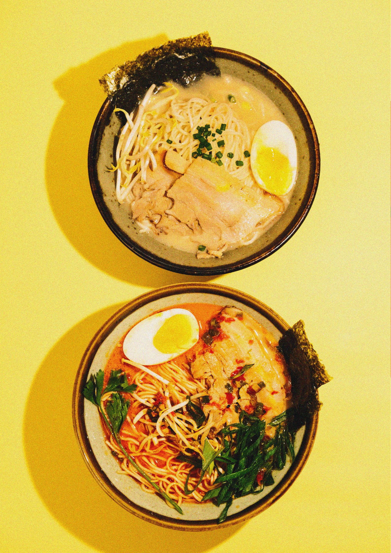 Two bowls of ramen with different toppings