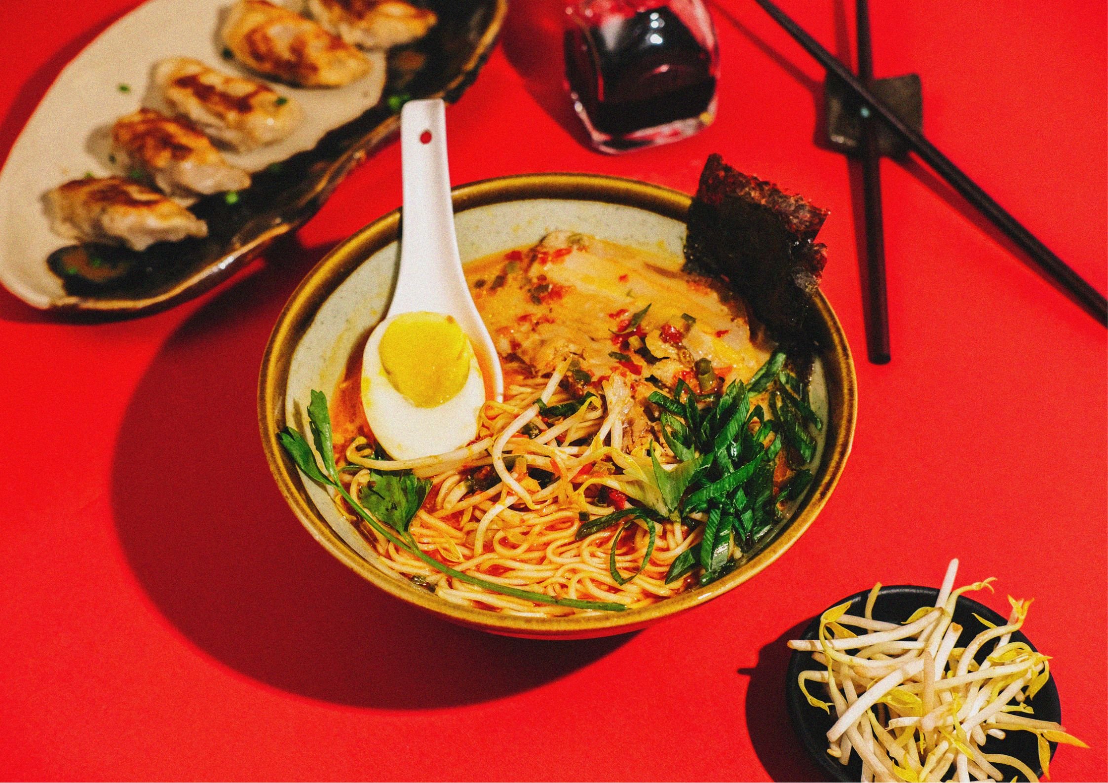 Ramen with toppings on red background