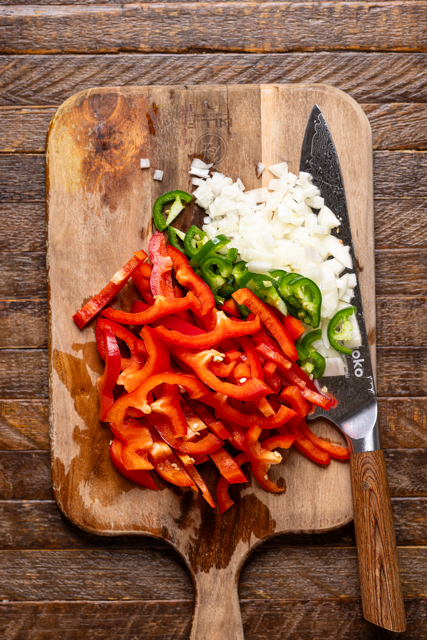 Image of chopped veggies on a cutting board with a knife.