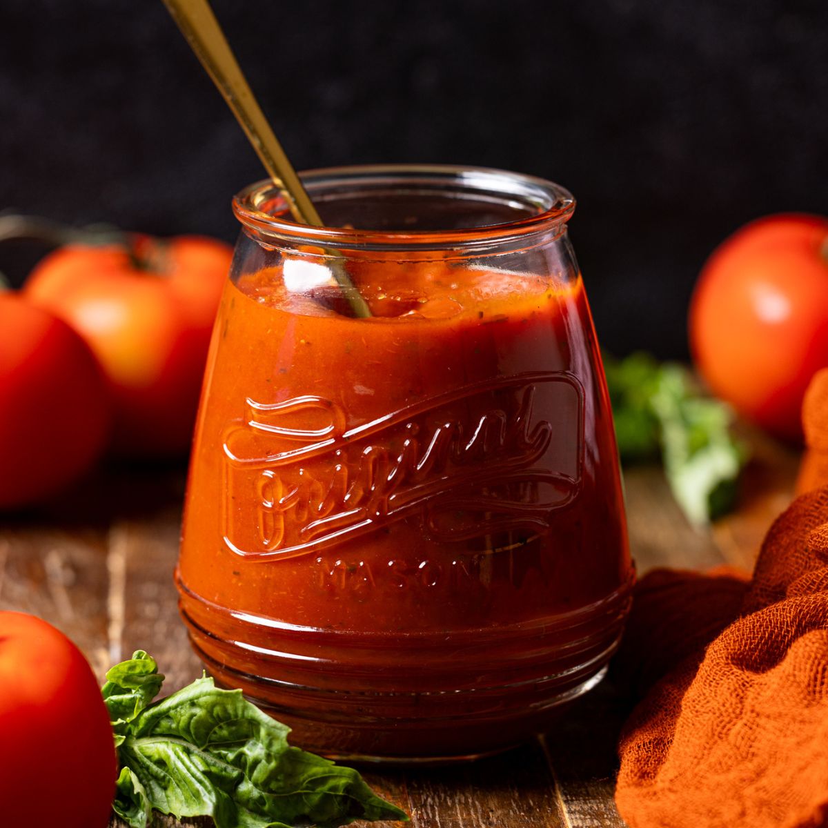 Image of pizza sauce in a jar with a spoon.