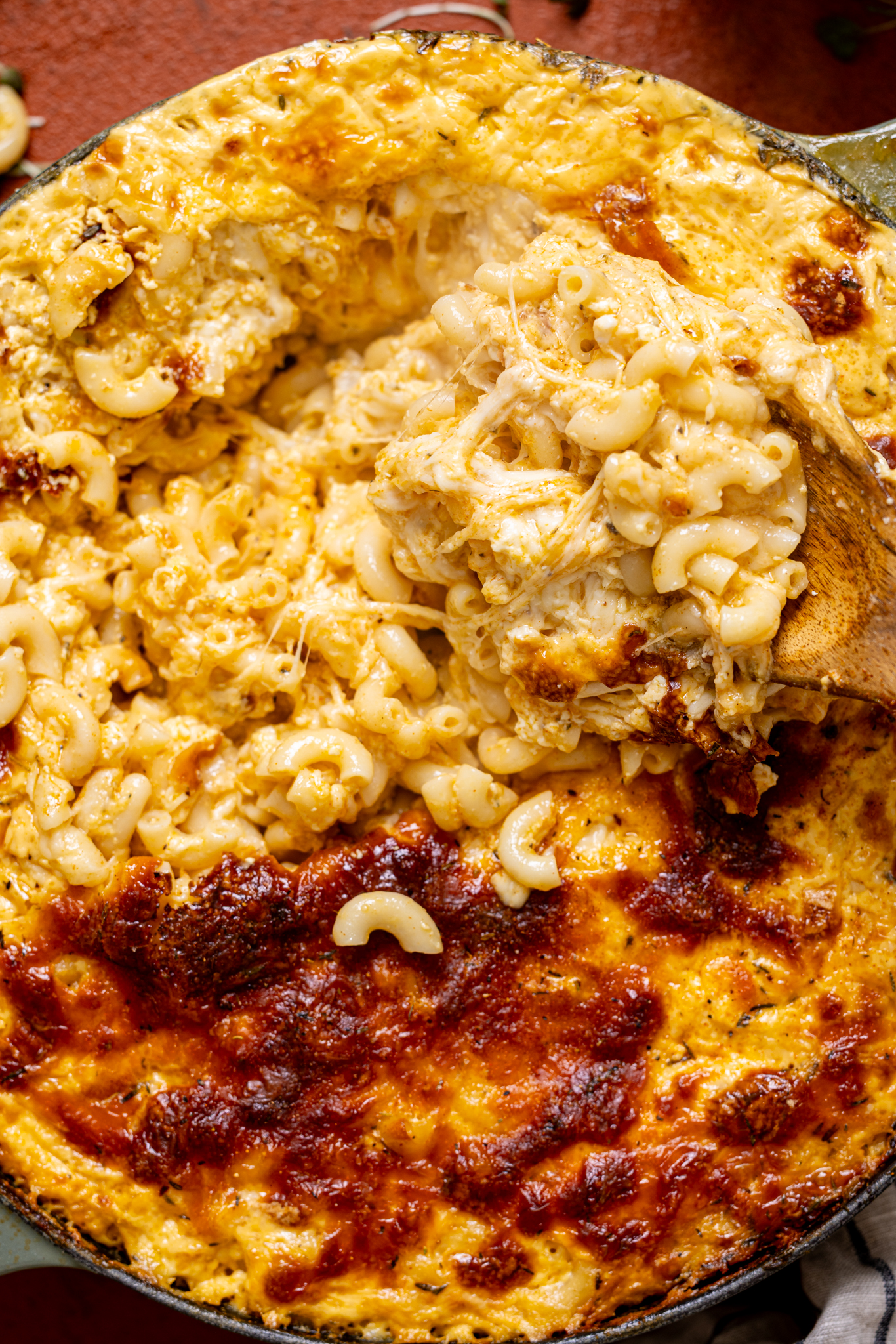 Up close shot of the Jerk Mac and Cheese being scooped with a wooden spoon.
