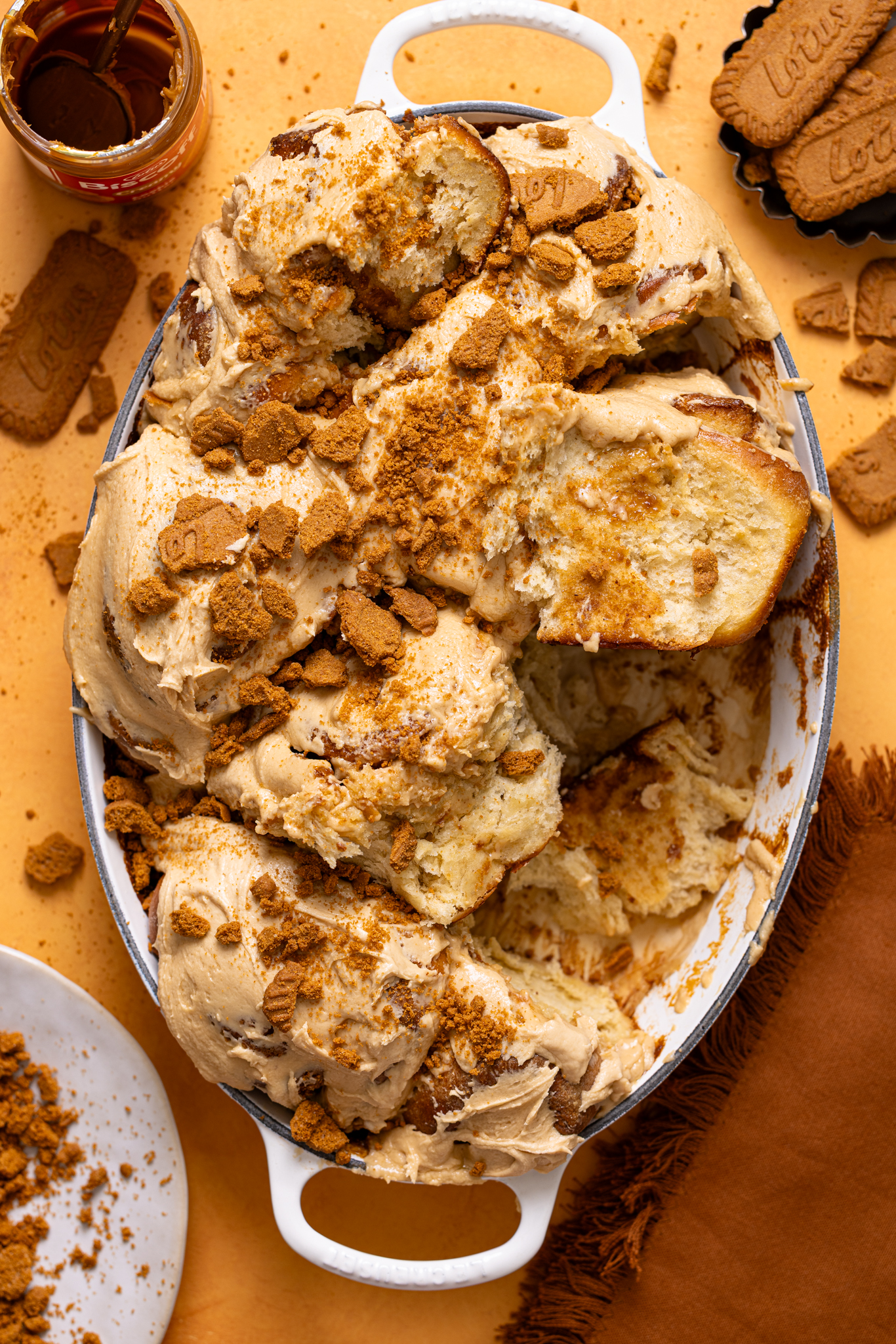 Biscoff Cookie Butter Cinnamon Rolls in a baking dish with cookies.