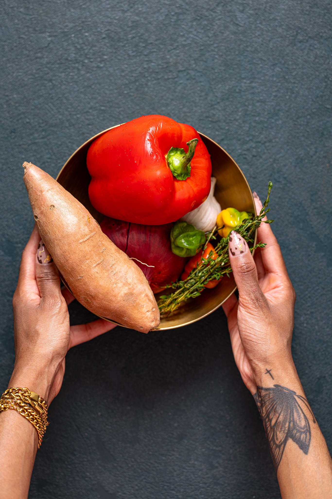 Veggies in a gold bowl being held by woman hands.