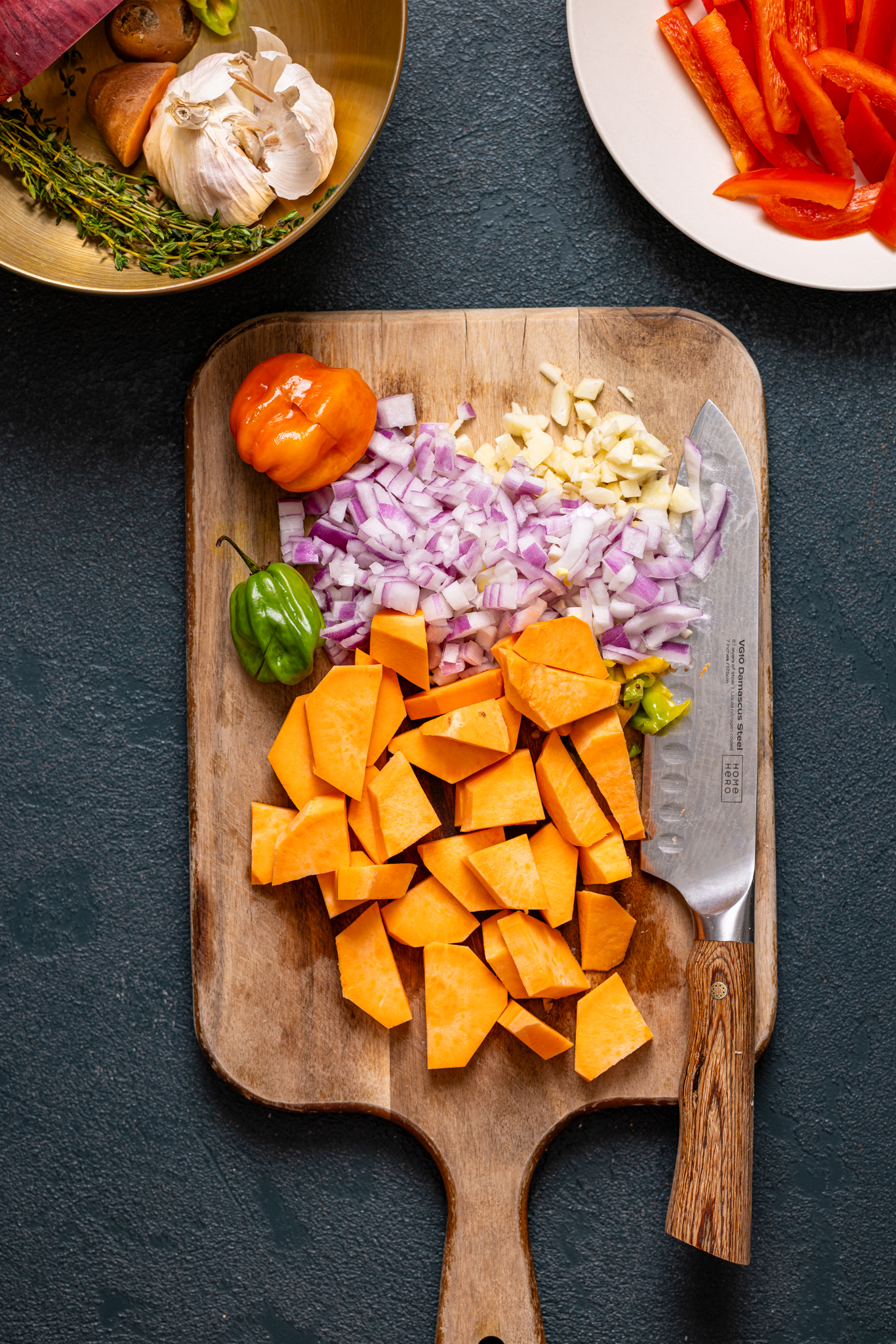 Chopped veggies on a cutting board with a knife.
