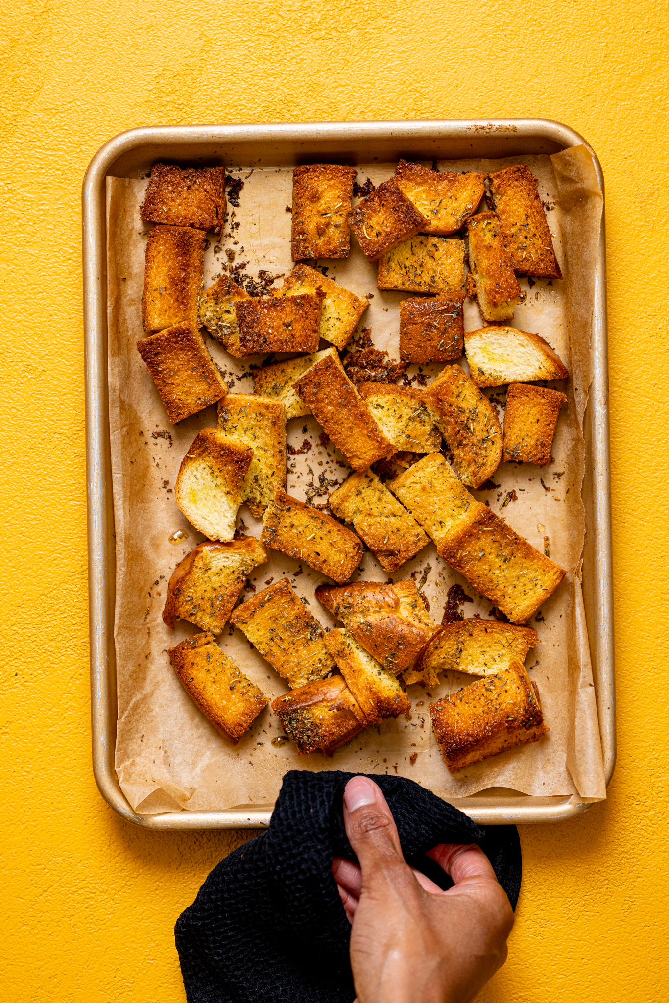 Homemade croutons on a baking sheet with parchment paper.