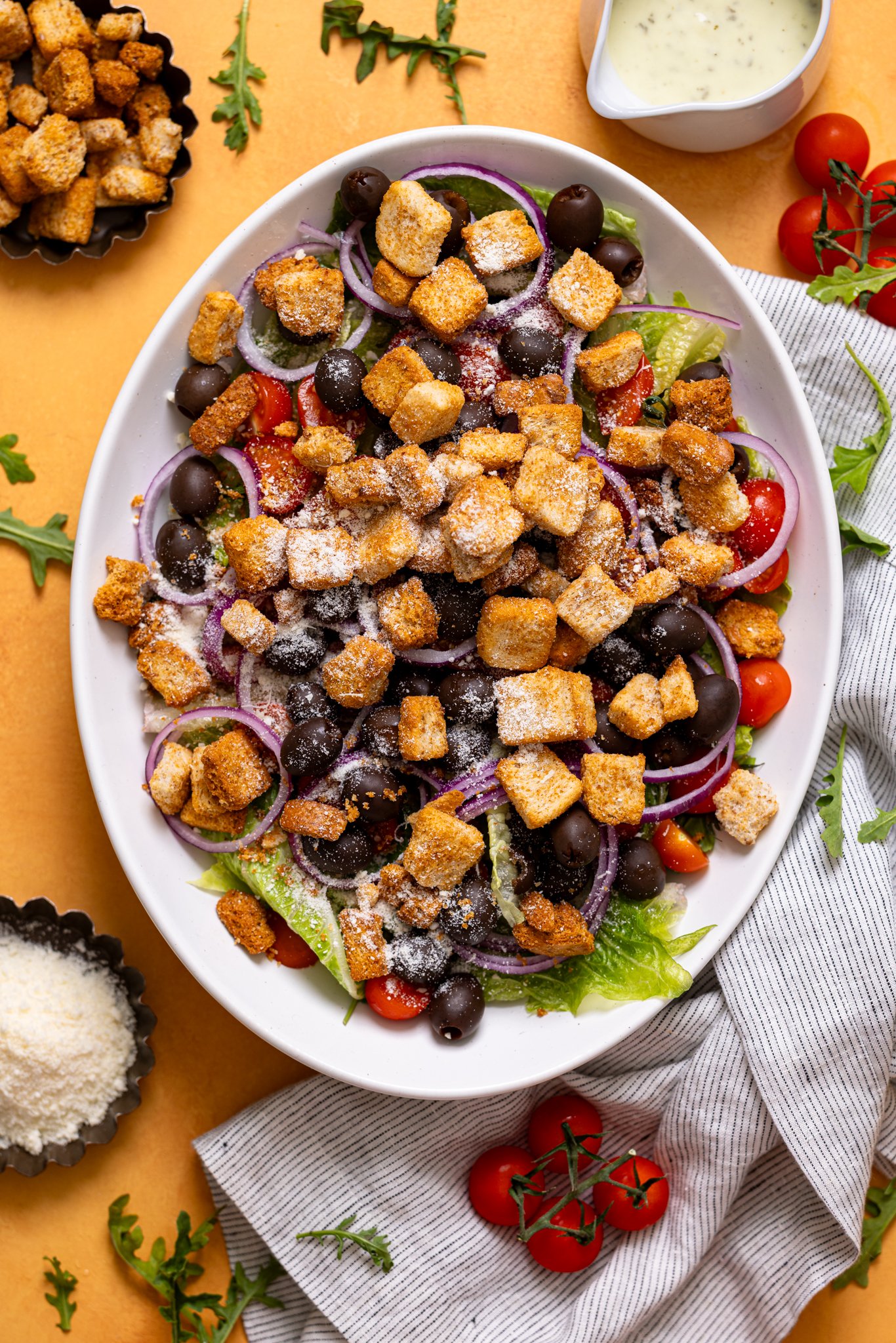 Copycat Olive Garden House Salad with Homemade Dressing on a platter with ingredients. 