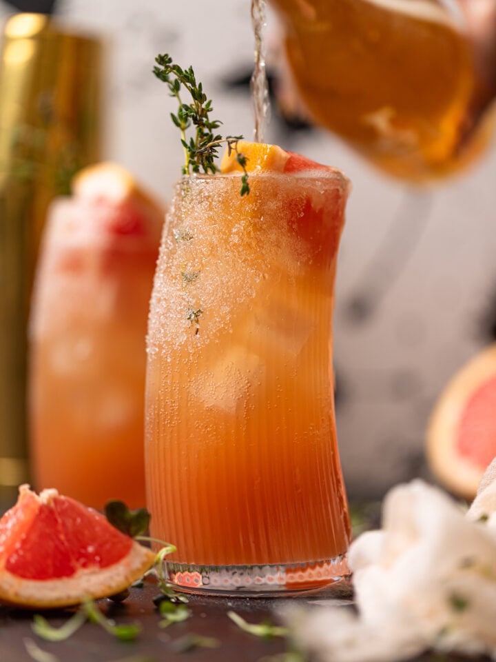 Champagne being poured into Grapefruit Aperol Spritz Mocktail.