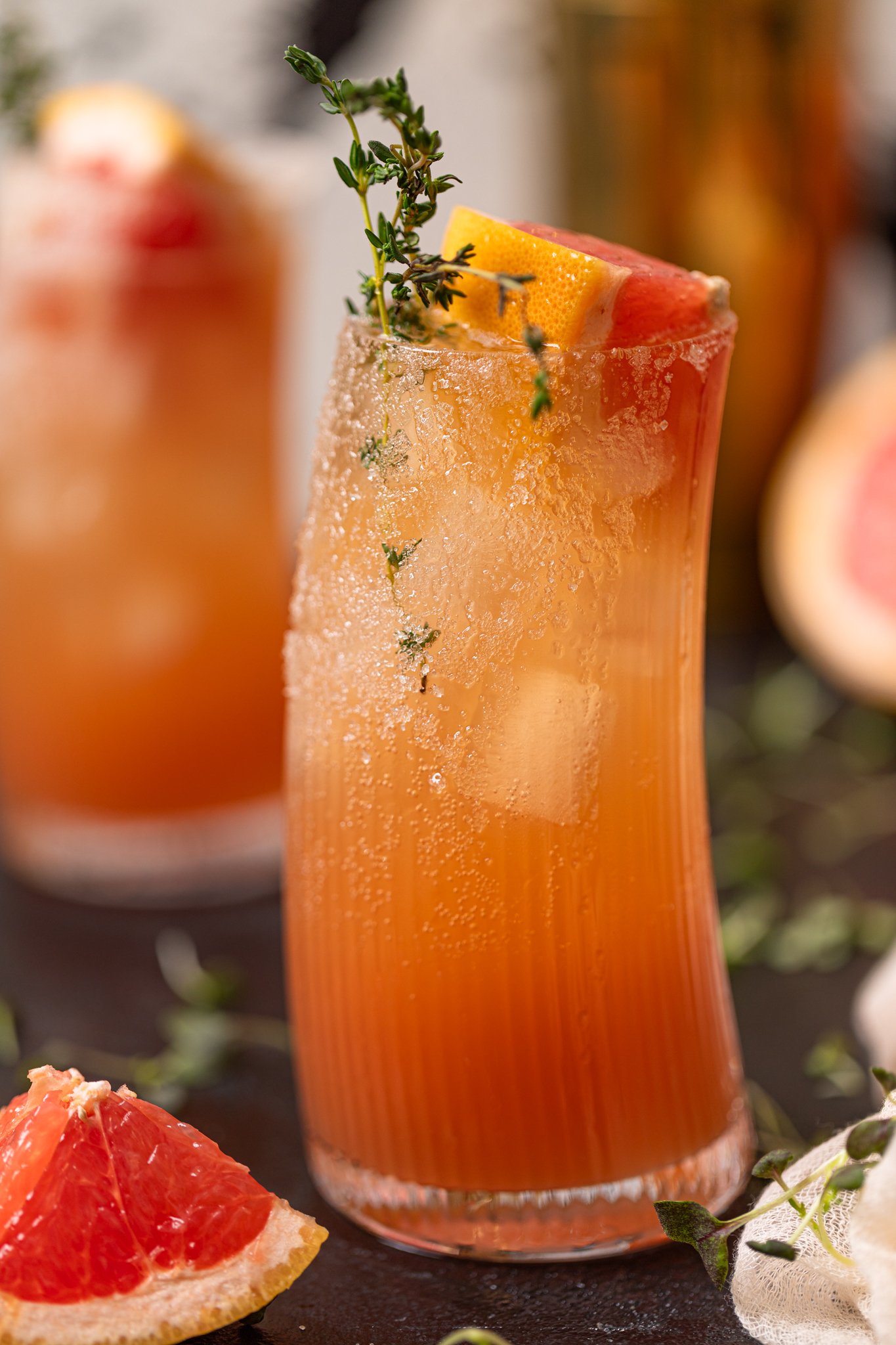 Grapefruit Aperol Spritz Mocktail with garnish and grapefruit wedges.