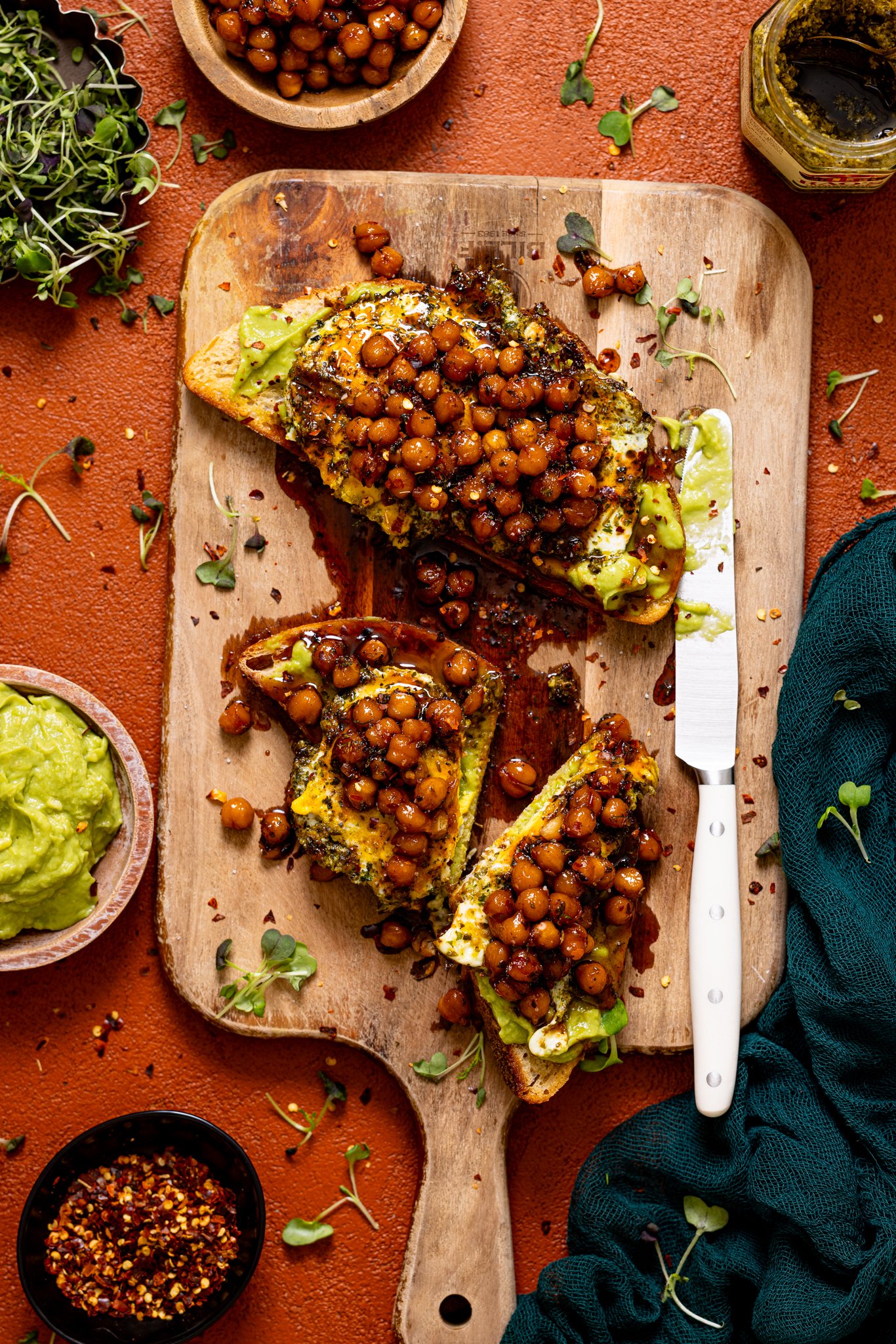 Morning Glory Pesto Egg Avocado Toast on a cutting board with a knife.