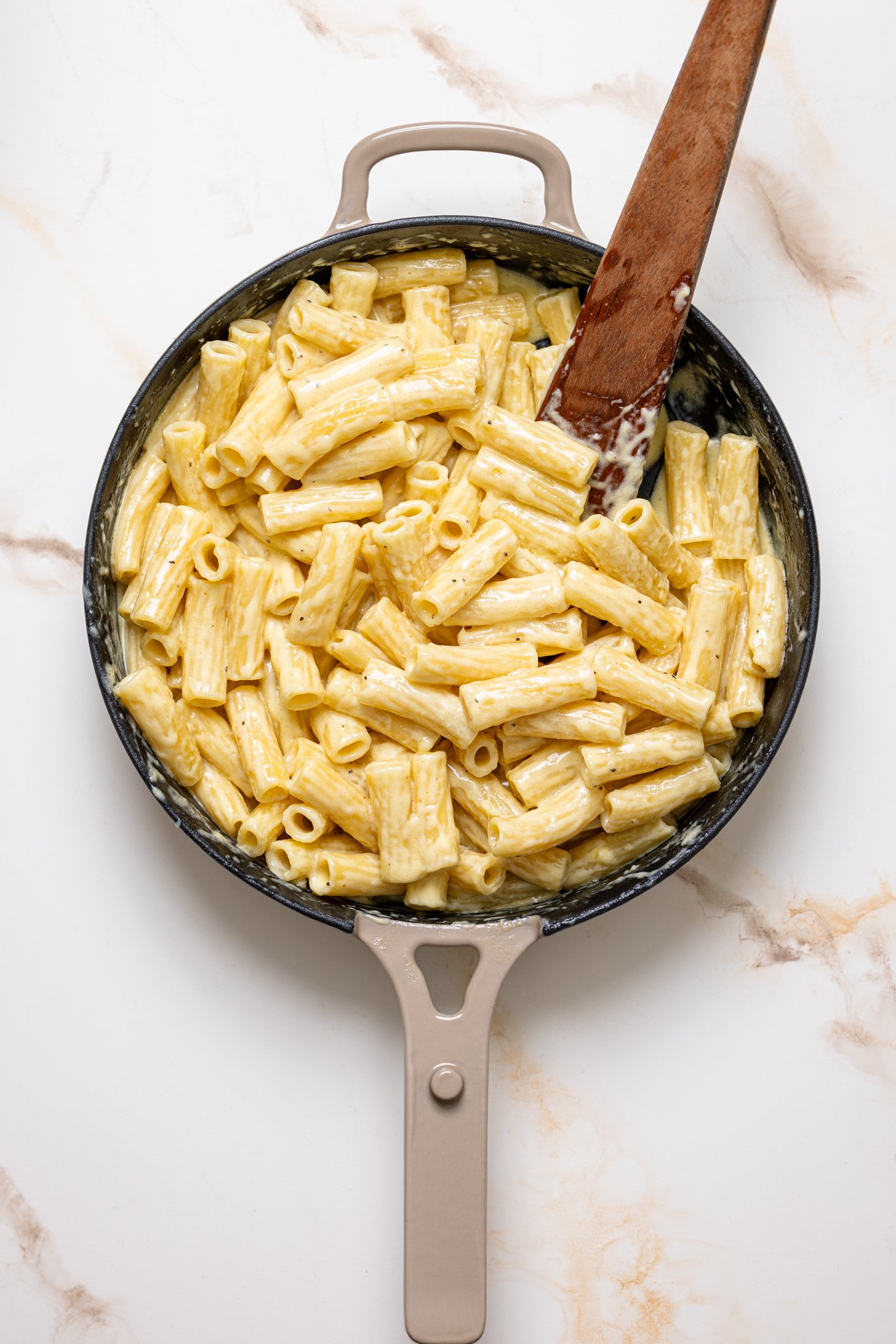 Creamy Weeknight Alfredo Pasta in a skillet with a wooden spoon.