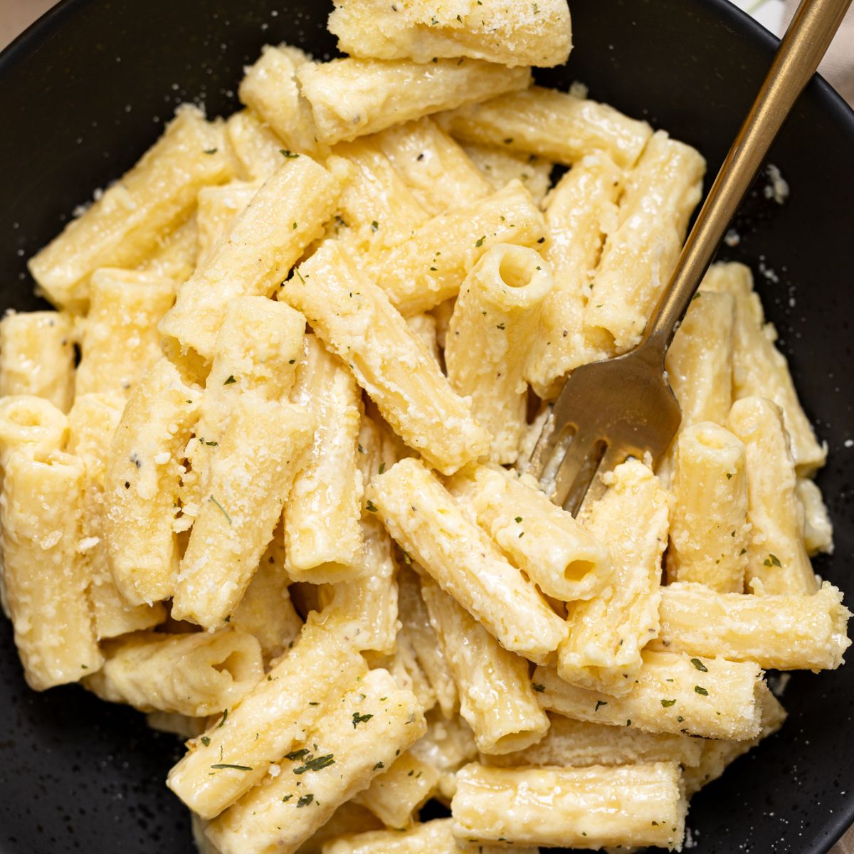 Up close shot of Creamy Weeknight Alfredo Pasta in a bowl with a fork.