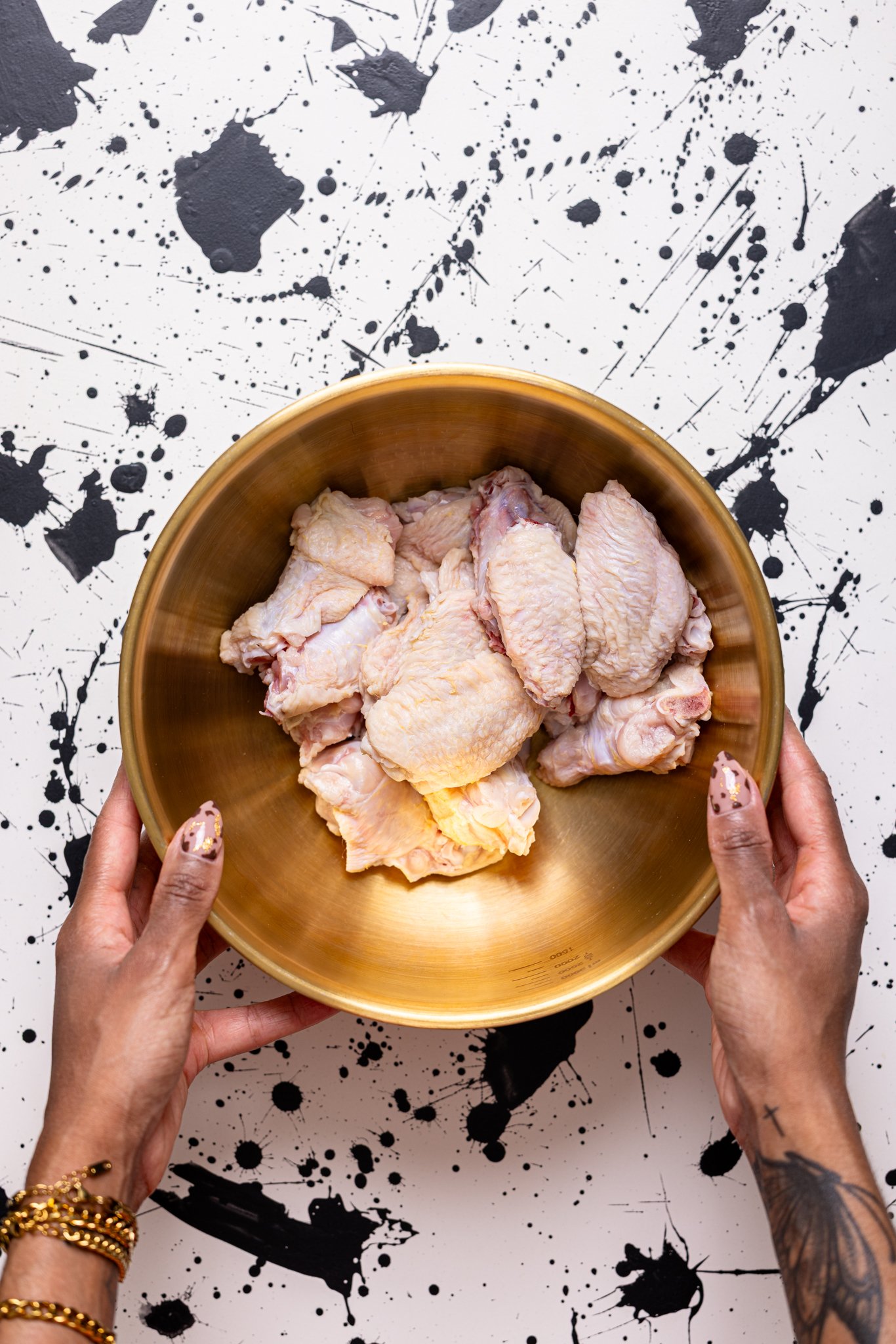 Clean chicken wings in a bowl being held by woman hands.
