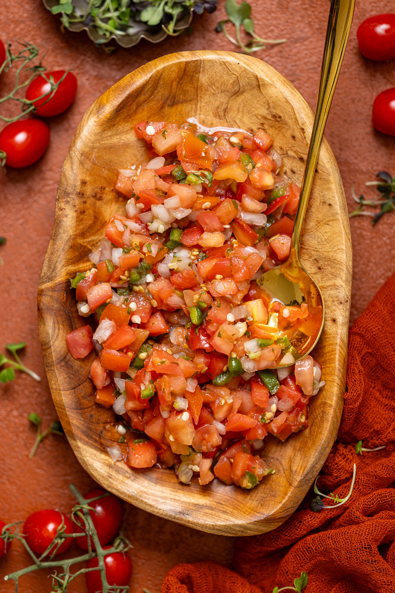 Fresh Pico de Gallo in a wooden bowl with a spoon.