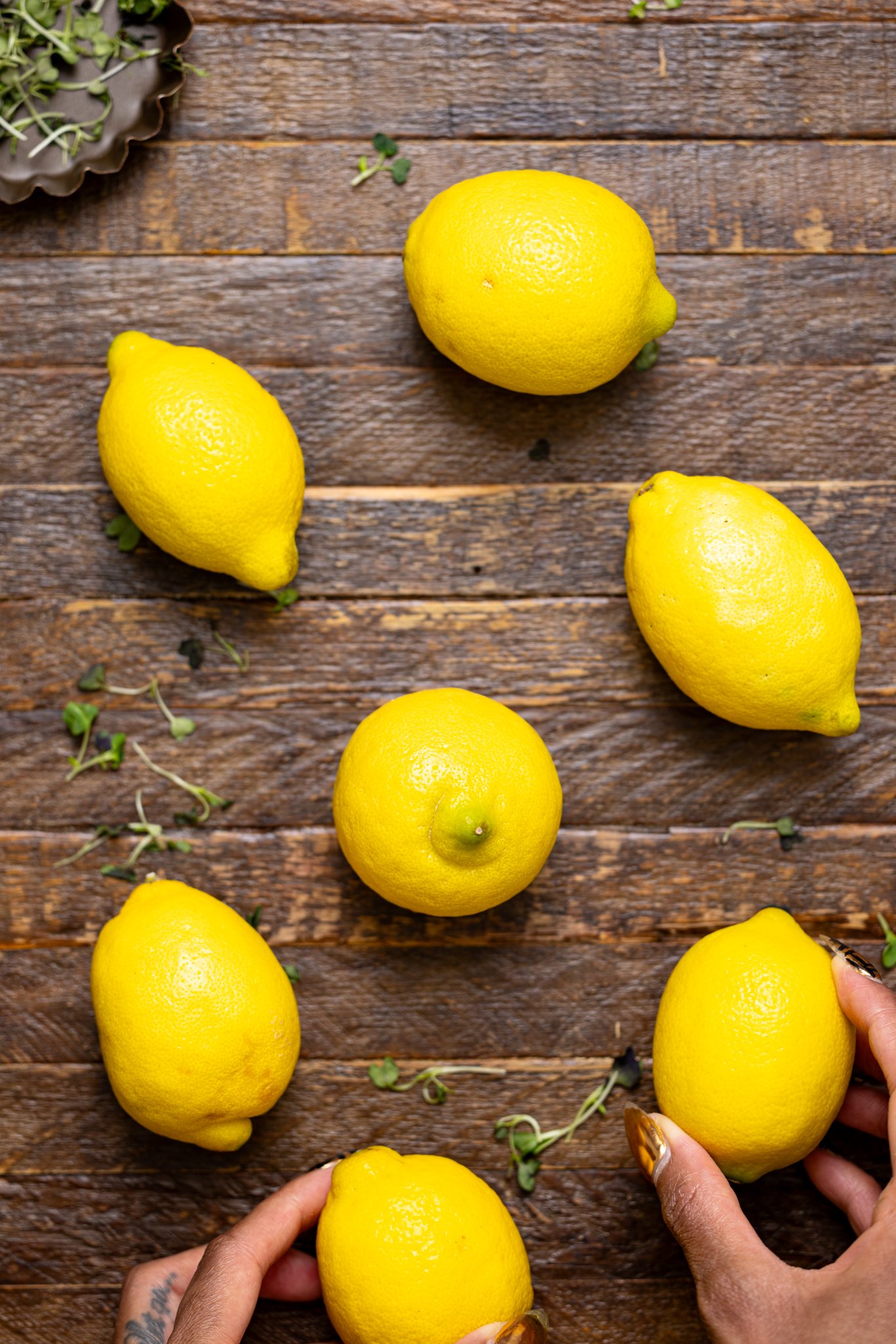 Lemons on a wood table with woman hands.