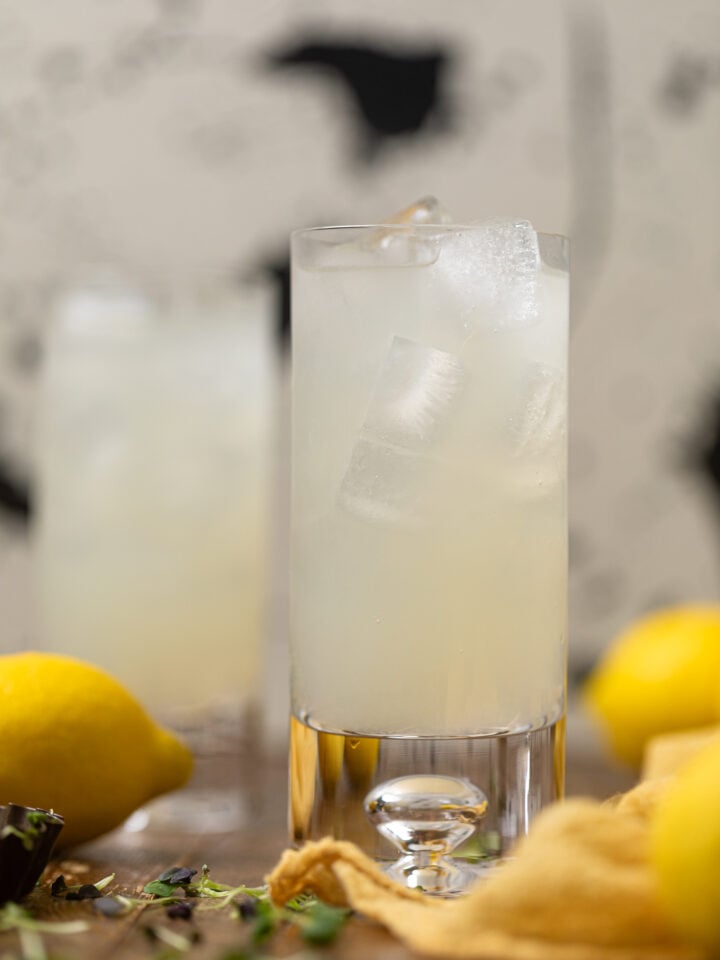Refreshing Homemade Lemonade with lemons in the background.