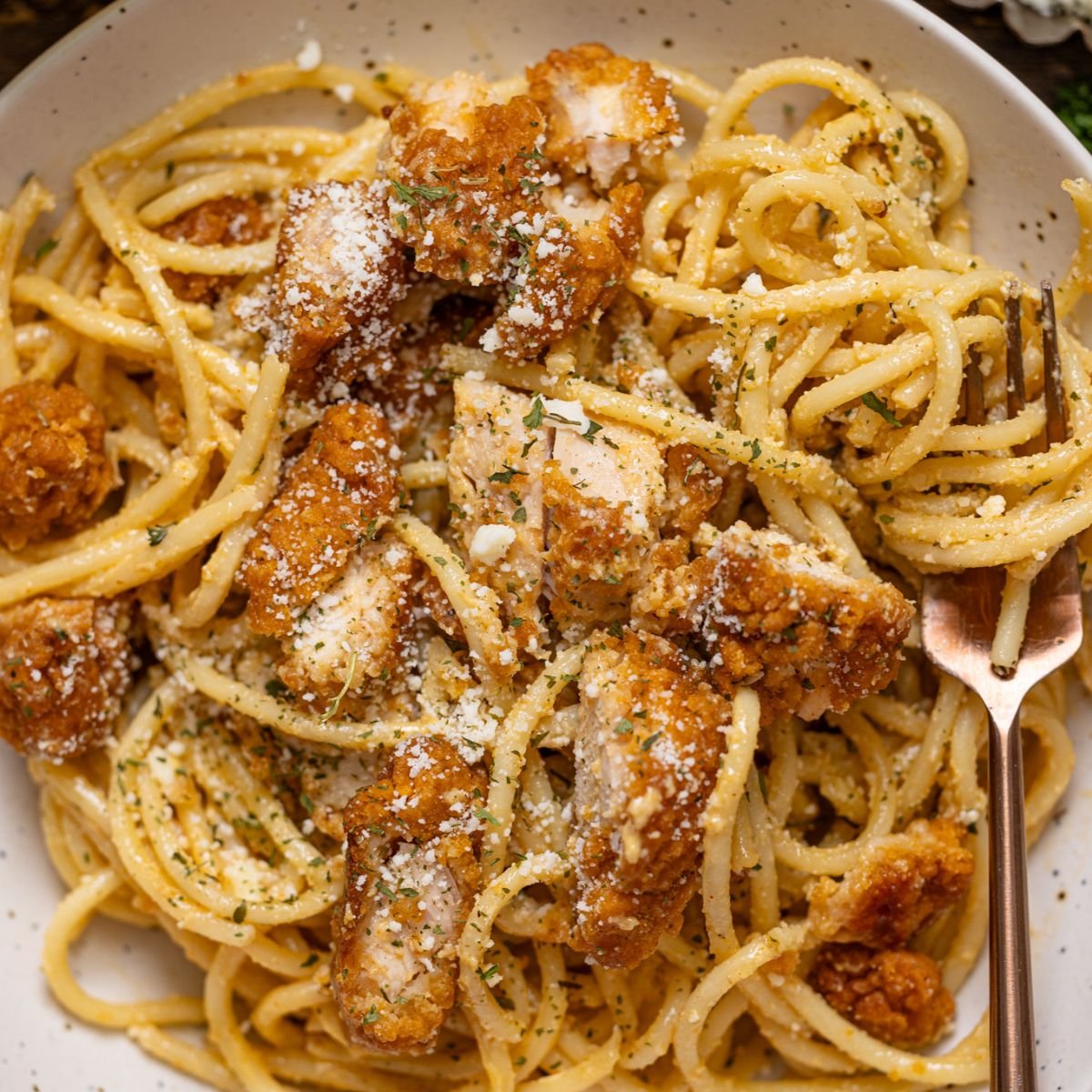 Up close shot of Southern Creamy Parmesan Garlic Chicken Pasta on a plate with a fork.