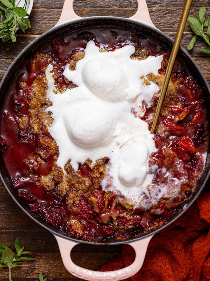 Southern Strawberry Dump Cake with ice cream and a gold serving spoon.