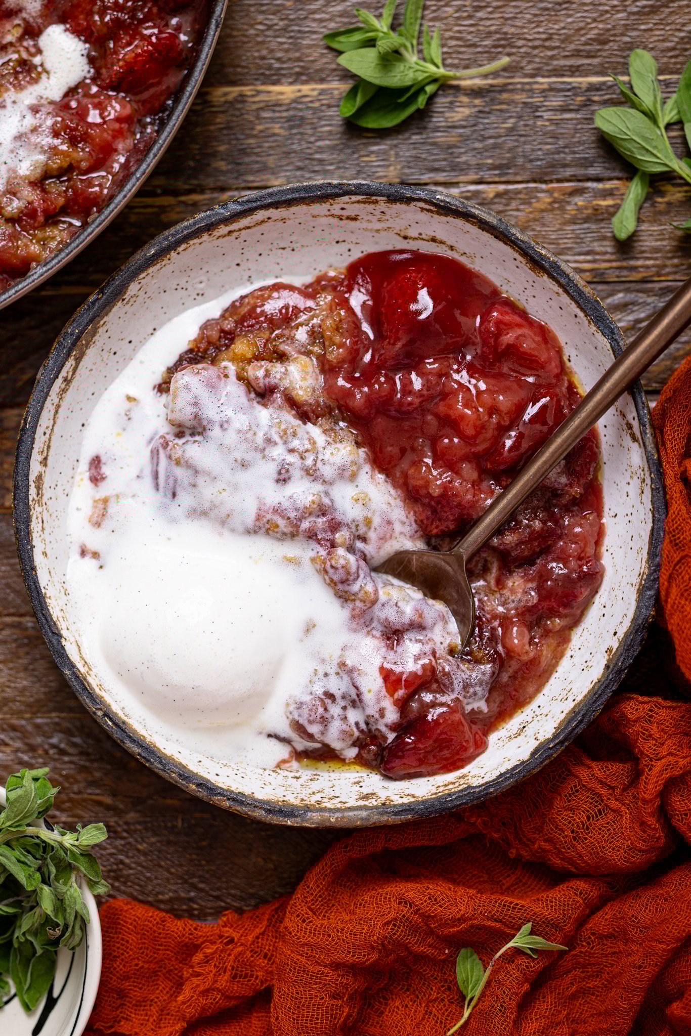 Southern Strawberry Dump Cake in a low bowl with ice cream and a spoon.