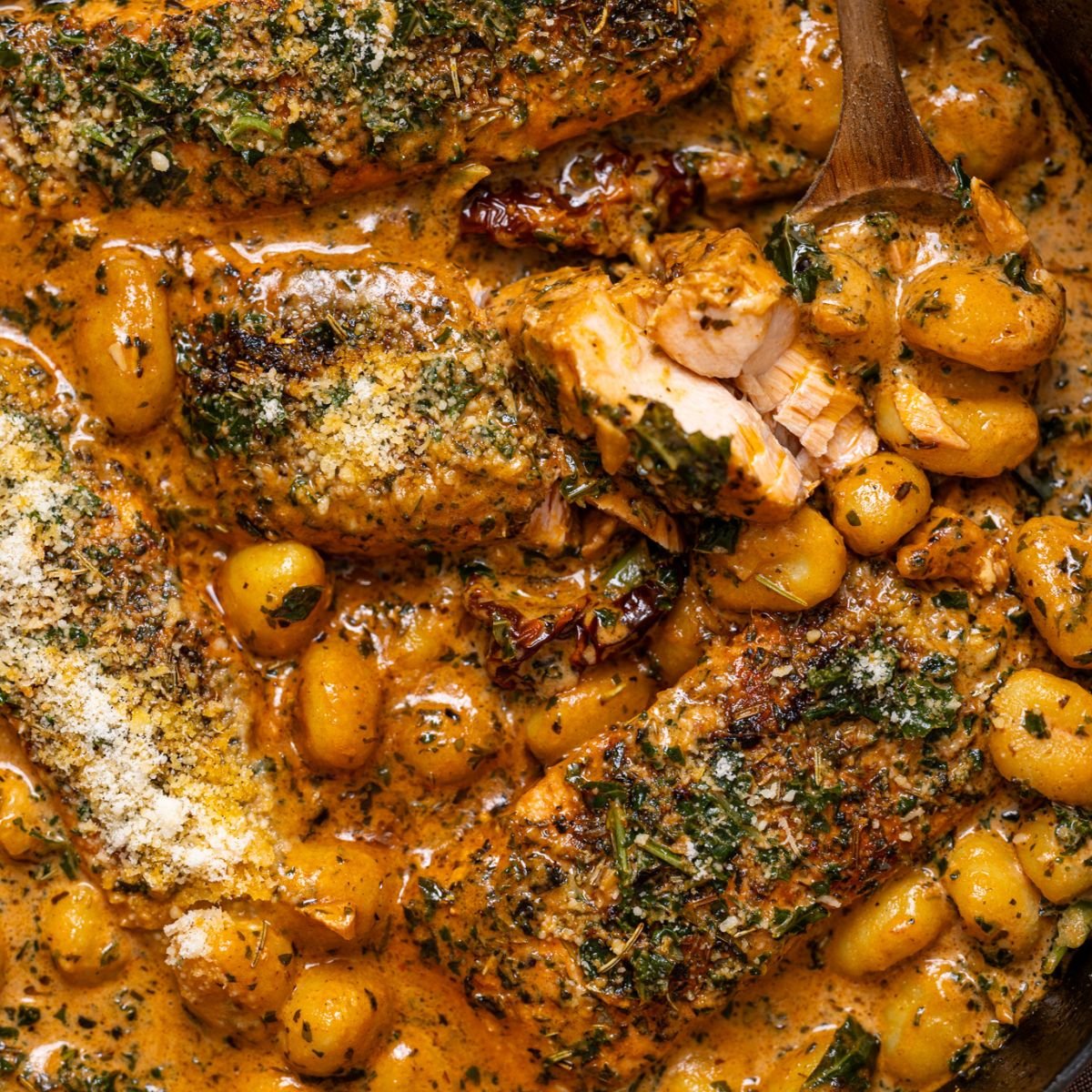Up close shot of The Best Tuscan Marry Me Salmon with gnocchi in a skillet.